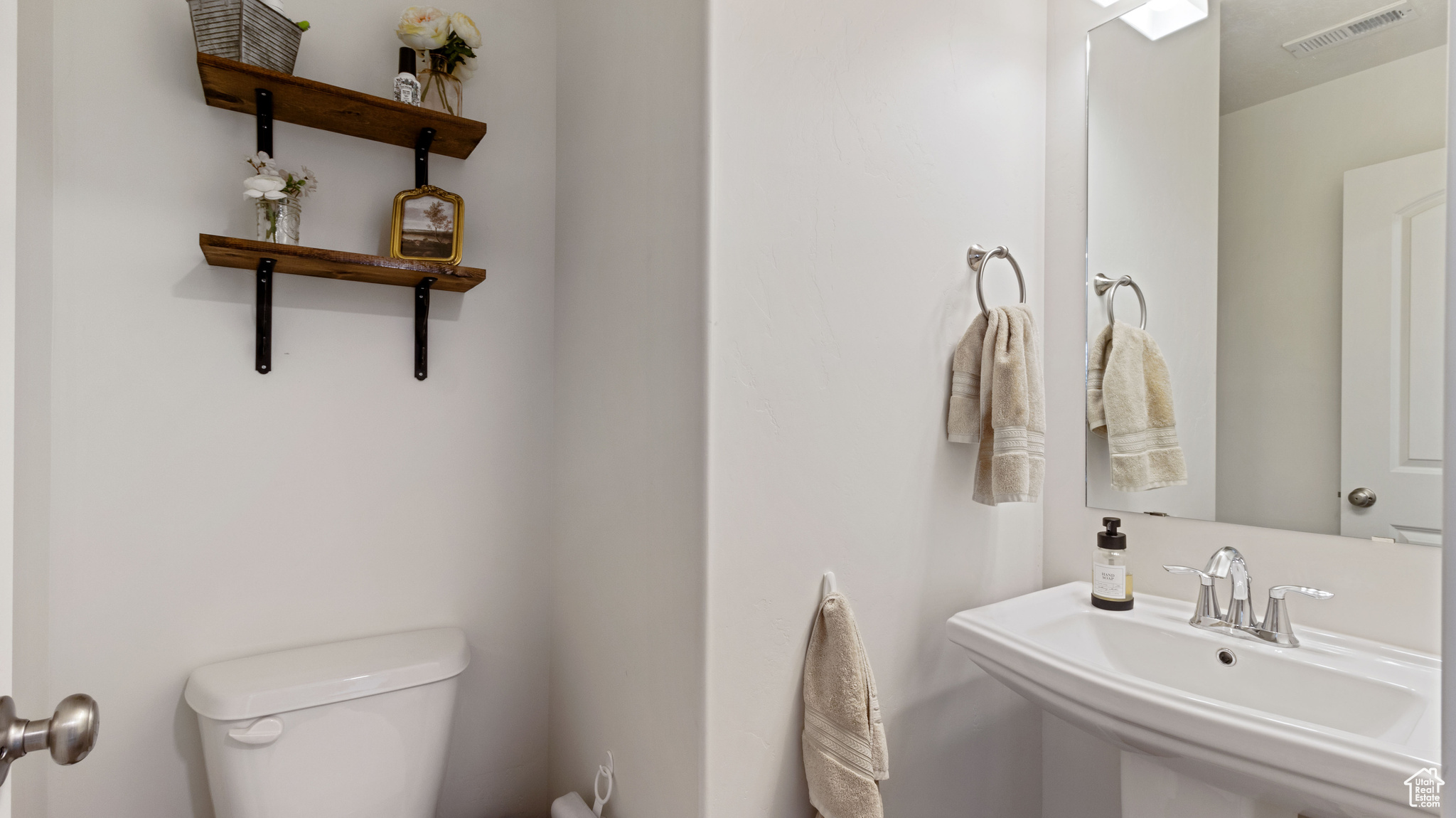 Bathroom with visible vents, toilet, and a sink