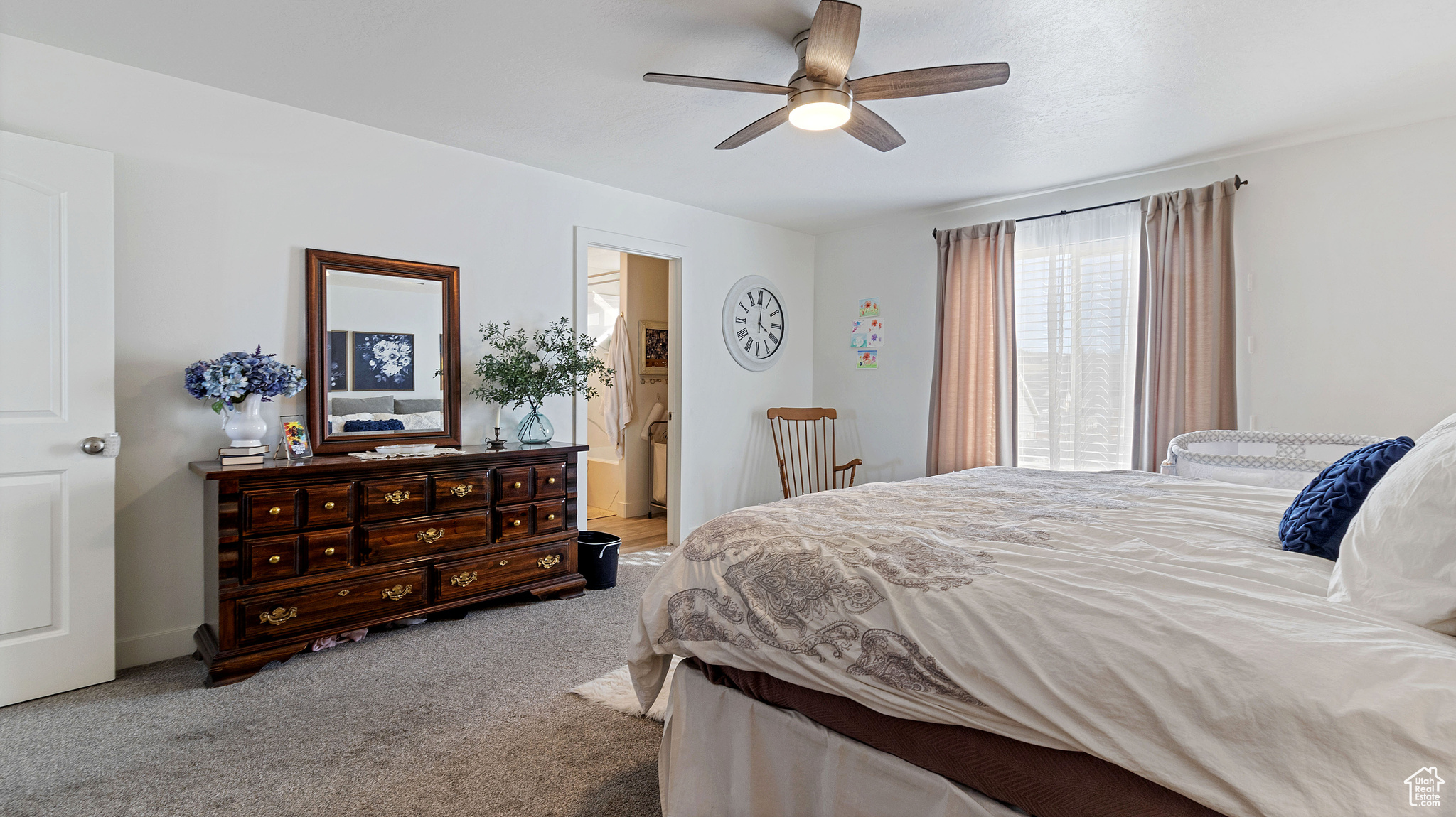 Bedroom featuring ensuite bathroom, ceiling fan, and carpet flooring