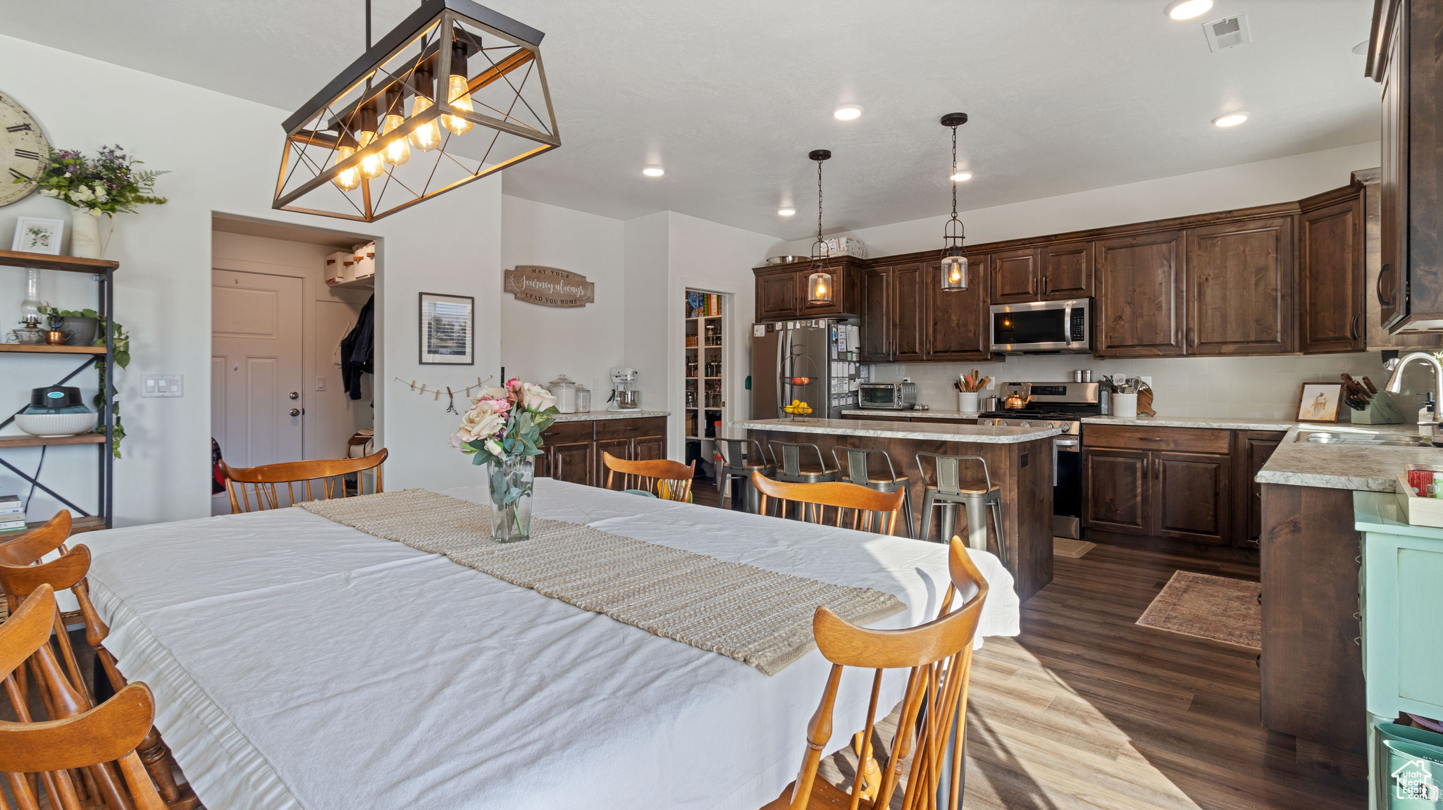 Dining room with recessed lighting, visible vents, dark wood LVP floors, and a toaster