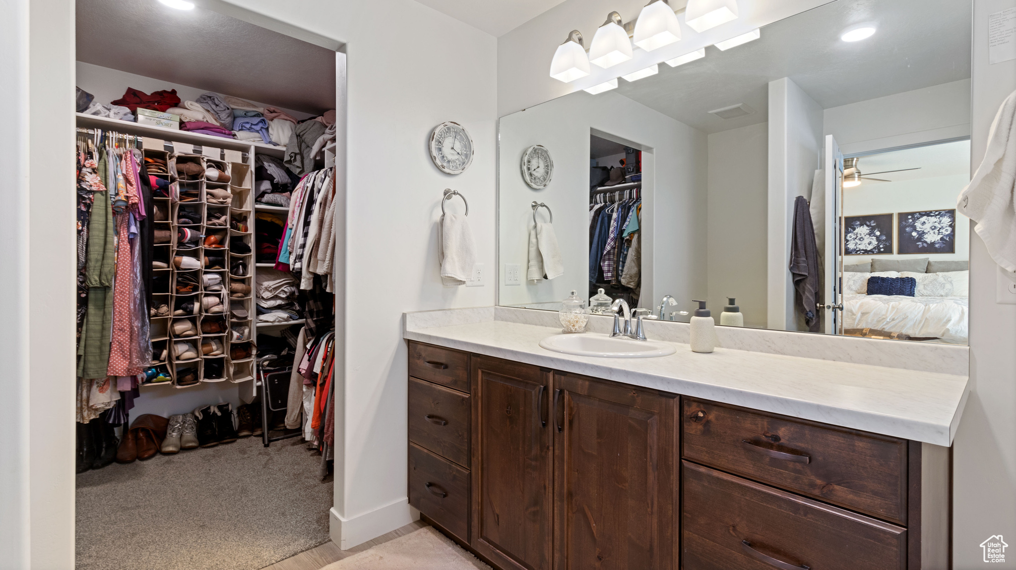 Ensuite bathroom with a walk in closet, baseboards, ceiling fan, ensuite bathroom, and vanity