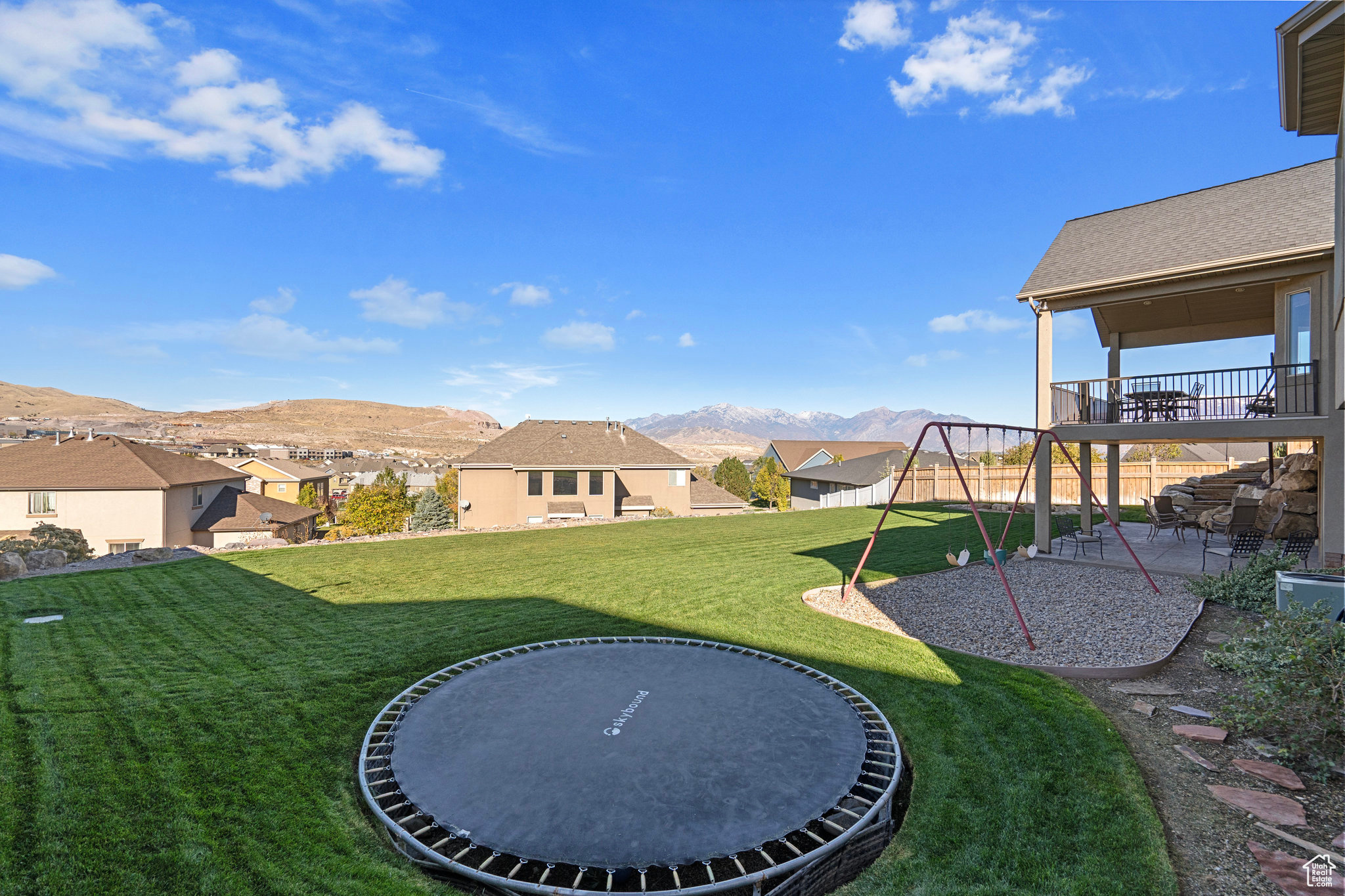 View of yard with a playground, fence, a residential view, a mountain view, and a patio