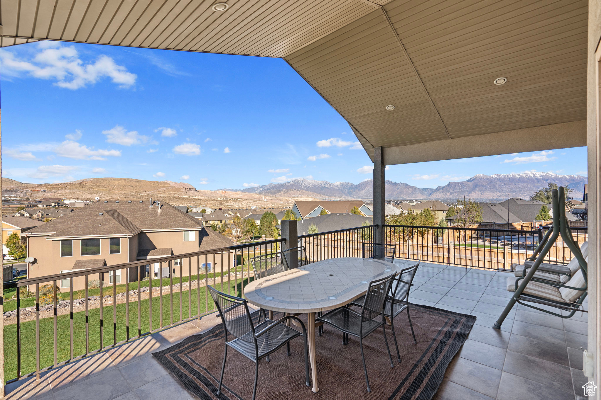 View of patio / terrace featuring a residential view, a mountain view, outdoor dining area, and a balcony