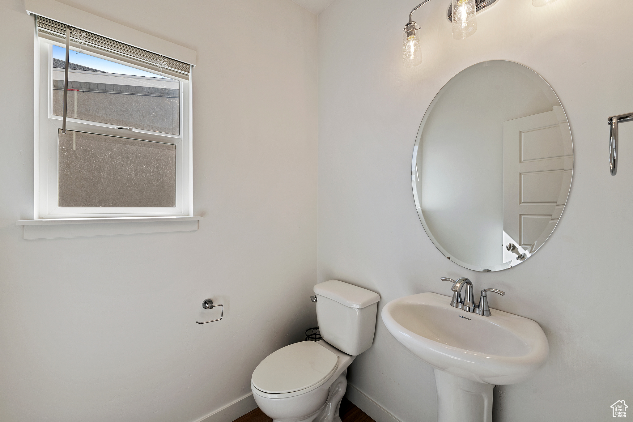 Bathroom with toilet, baseboards, and a sink