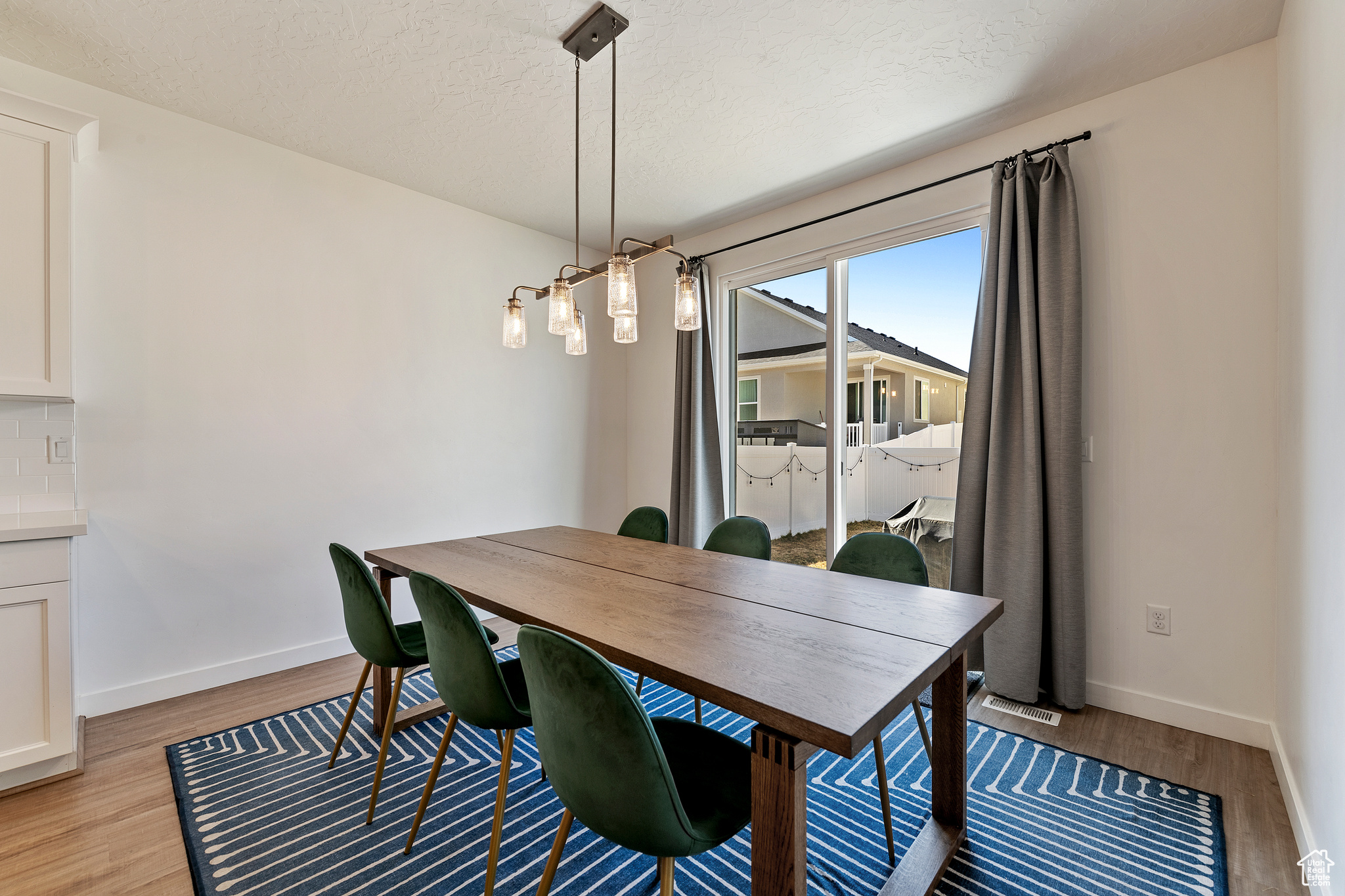 Dining area with light wood-style floors, baseboards, and a textured ceiling