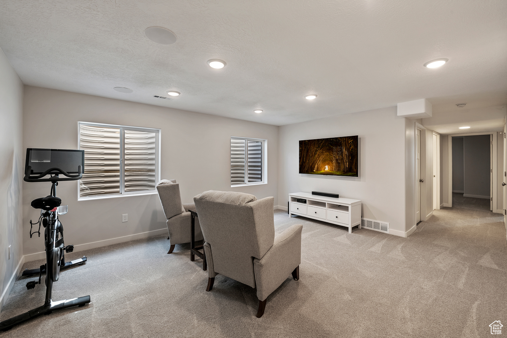 Living room with light carpet, recessed lighting, and baseboards