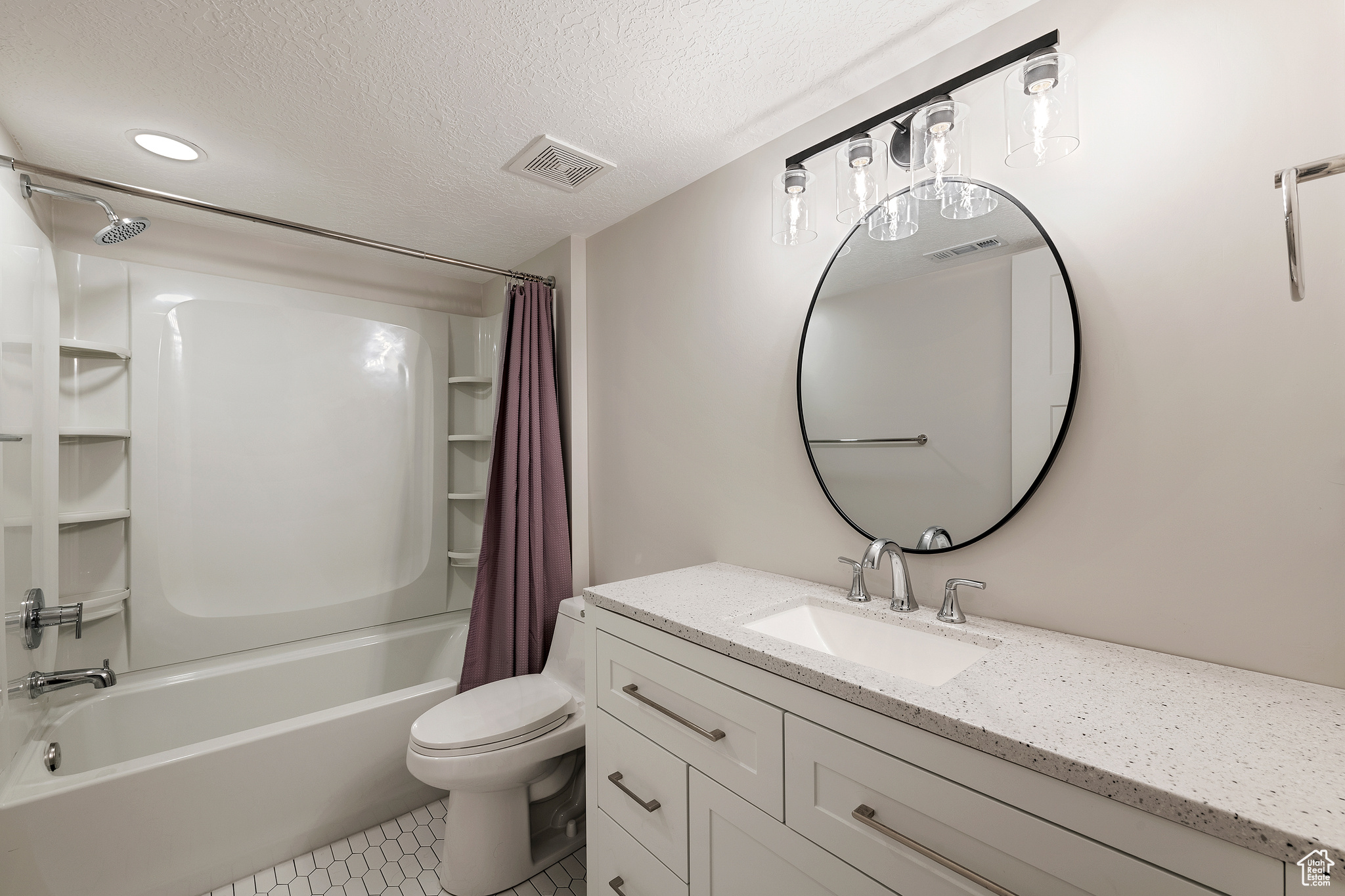 Bathroom with toilet, visible vents, shower / tub combo with curtain, and a textured ceiling