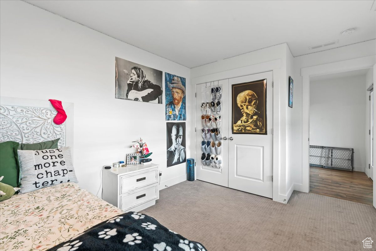 Bedroom featuring a closet, carpet flooring, and visible vents