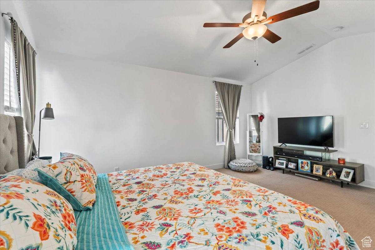 Bedroom featuring visible vents, baseboards, lofted ceiling, ceiling fan, and carpet floors