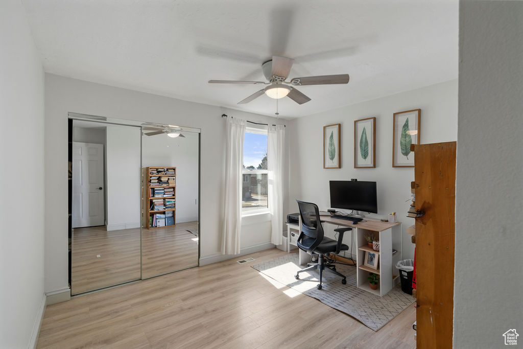 Office featuring a ceiling fan, visible vents, wood finished floors, and baseboards