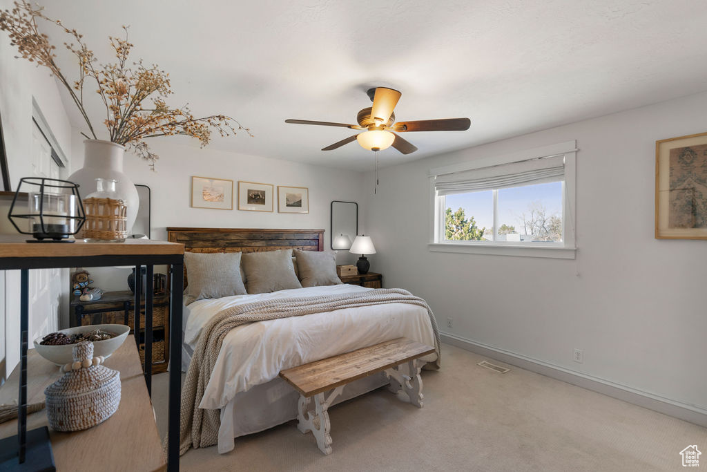 Carpeted bedroom featuring visible vents, ceiling fan, and baseboards