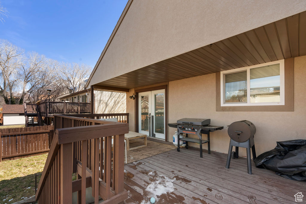 Deck featuring area for grilling, fence, and french doors