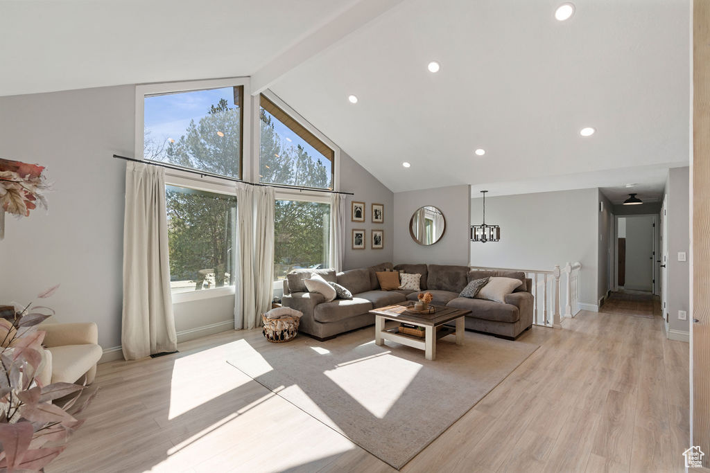 Living room with baseboards, high vaulted ceiling, light wood-style flooring, recessed lighting, and beamed ceiling