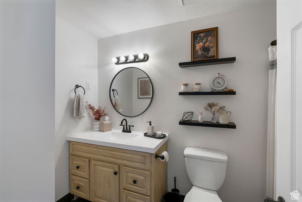 Full bath featuring vanity and toilet