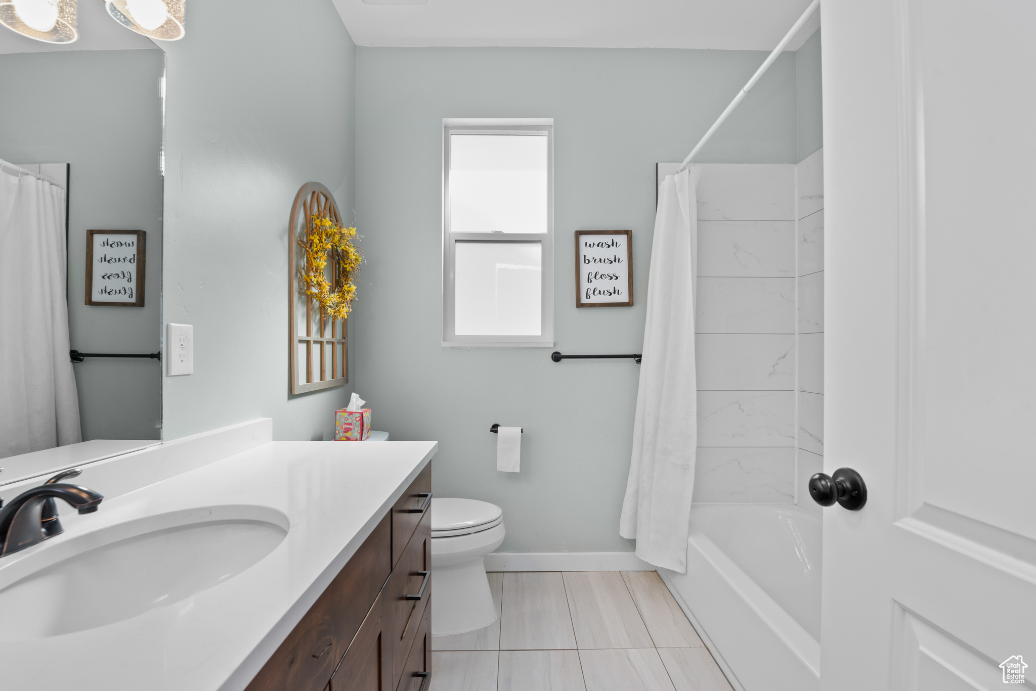 Full bath featuring toilet, shower / tub combo, baseboards, and vanity