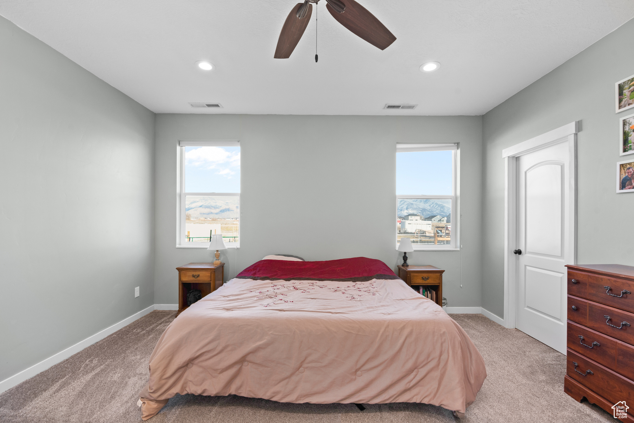 Bedroom with light colored carpet, visible vents, baseboards, and recessed lighting