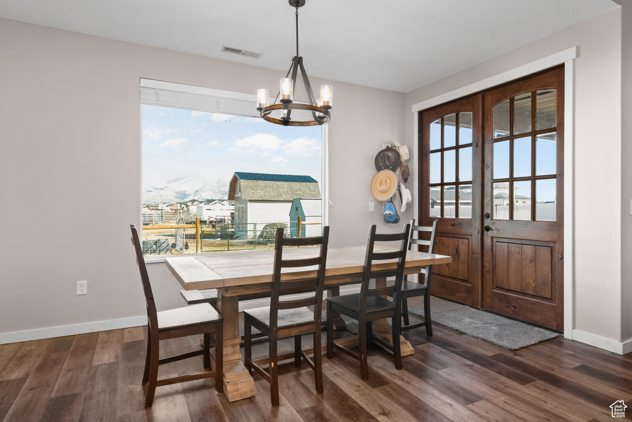 Dining space with french doors, a wealth of natural light, dark wood finished floors, and visible vents