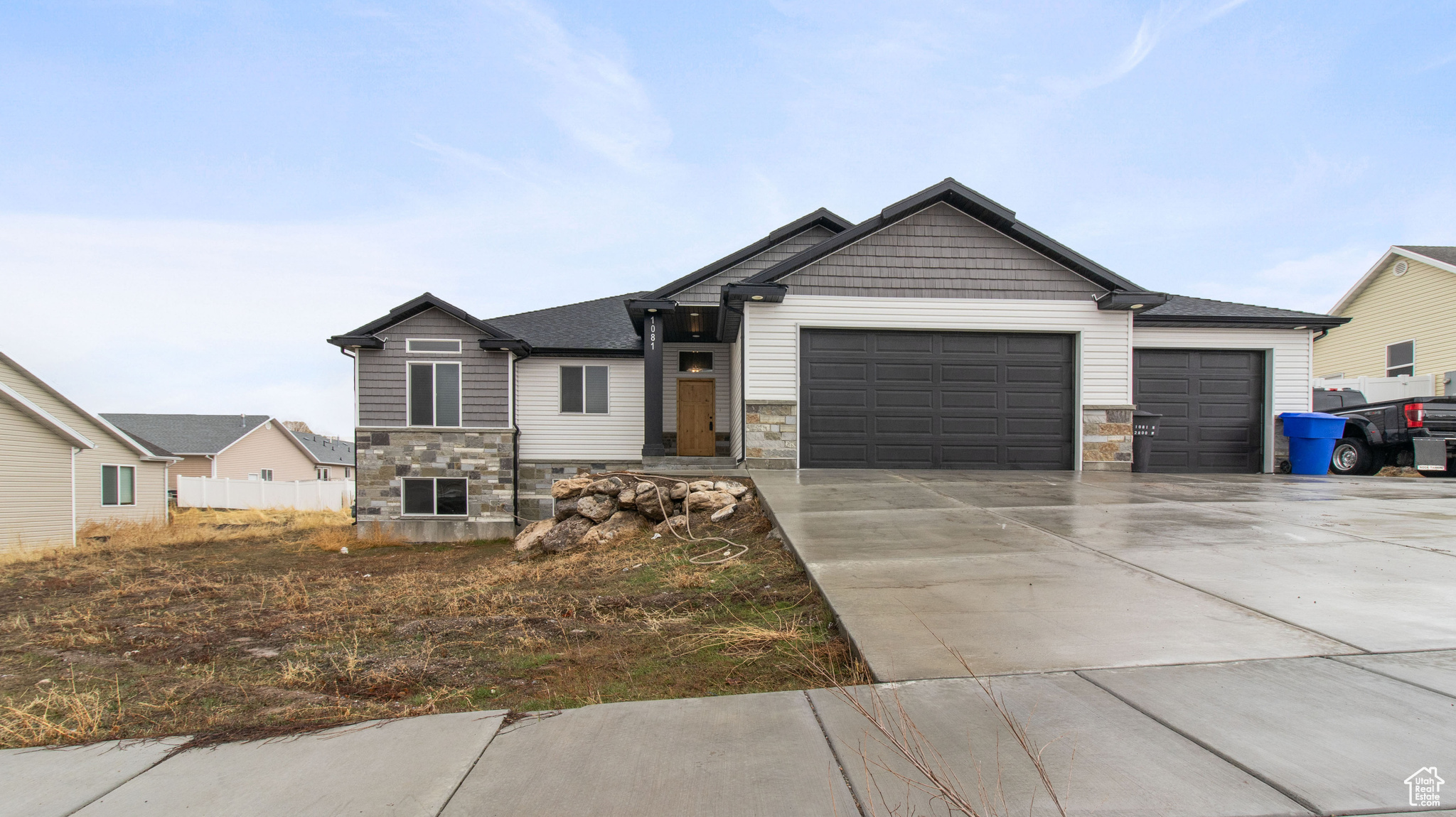 Craftsman-style home featuring stone siding, concrete driveway, and an attached garage