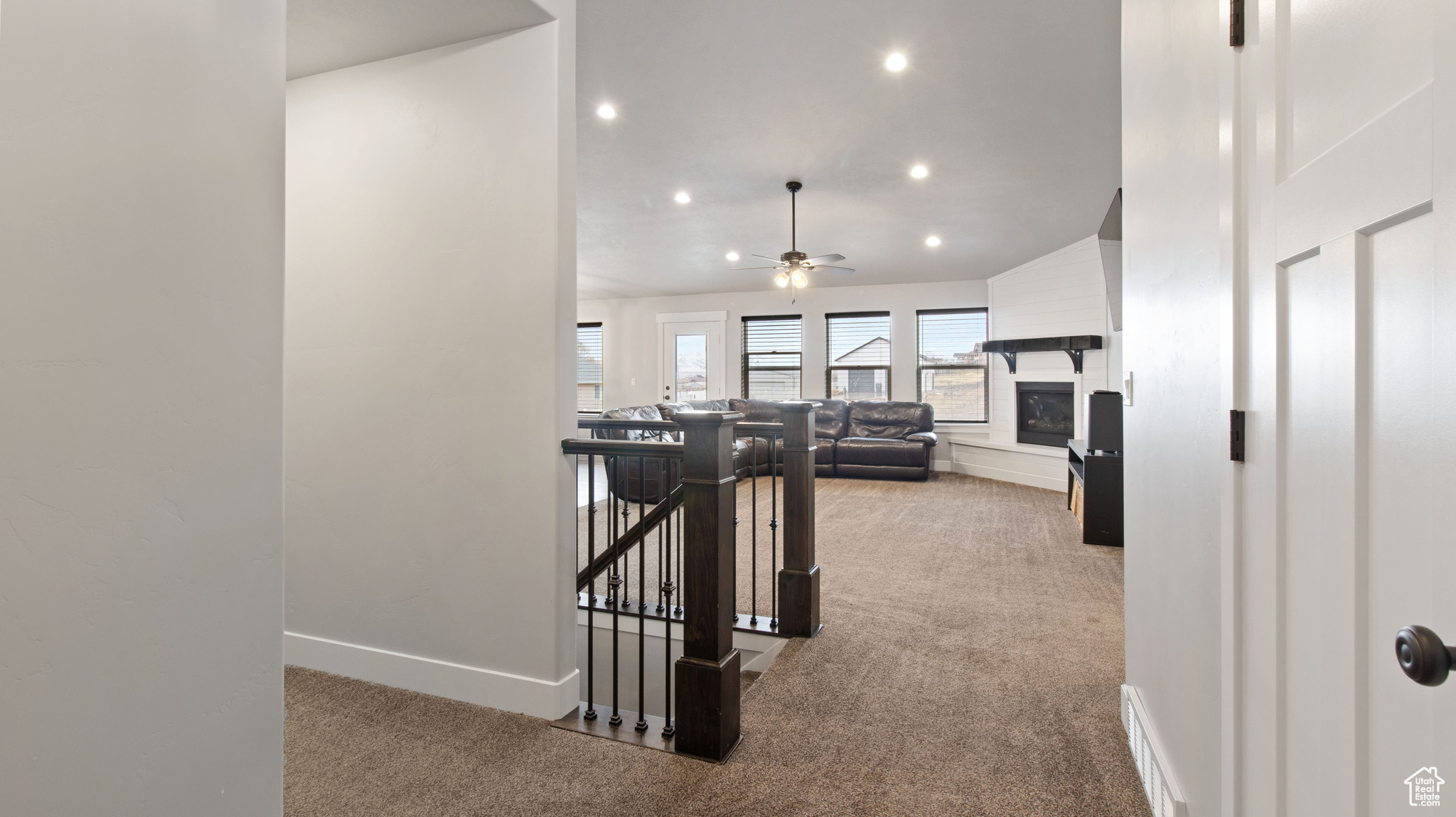 Hallway with visible vents, baseboards, carpet, an upstairs landing, and recessed lighting