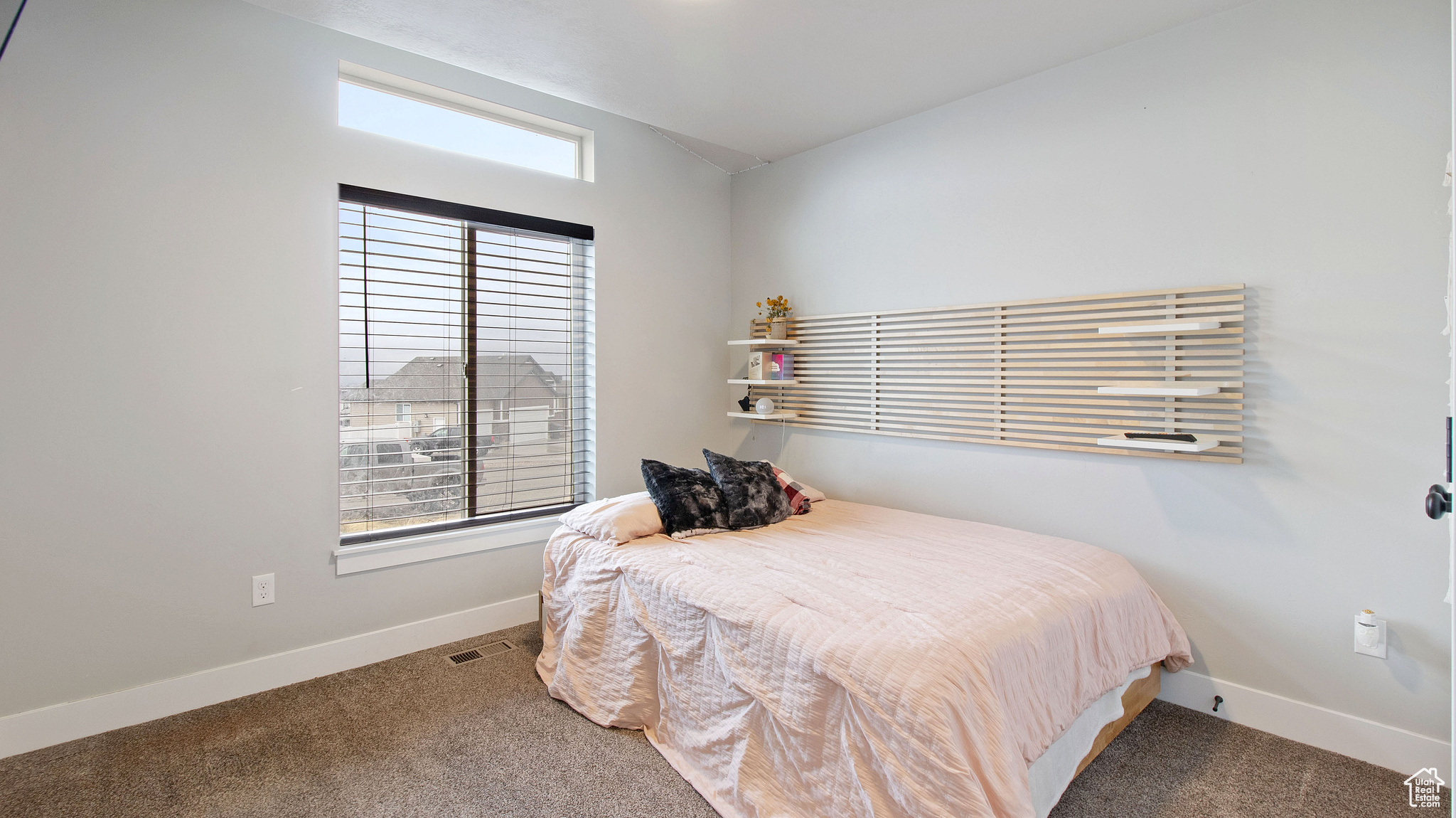 Carpeted bedroom with visible vents, baseboards, and vaulted ceiling