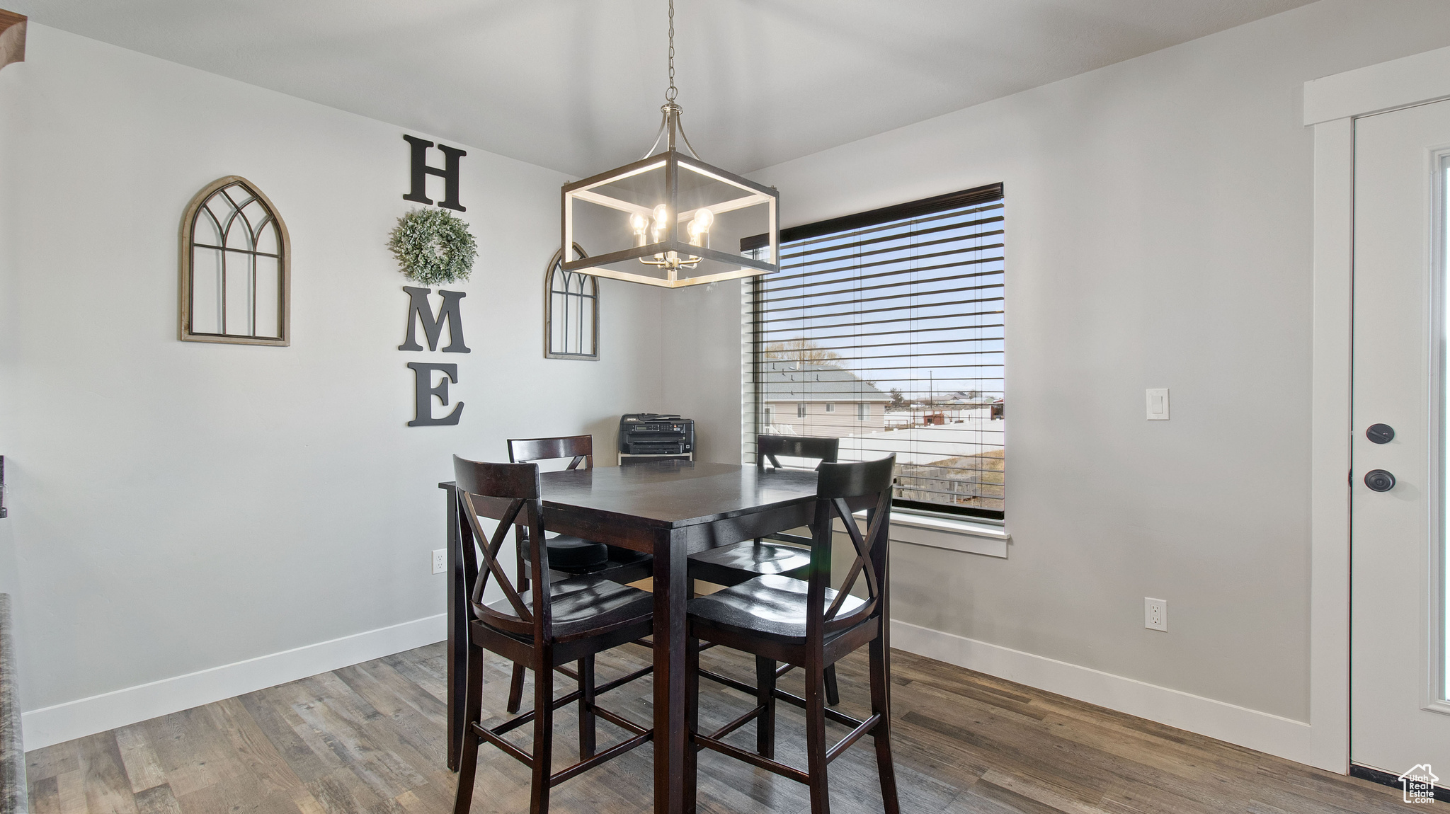 Dining room featuring an inviting chandelier, baseboards, and wood finished floors