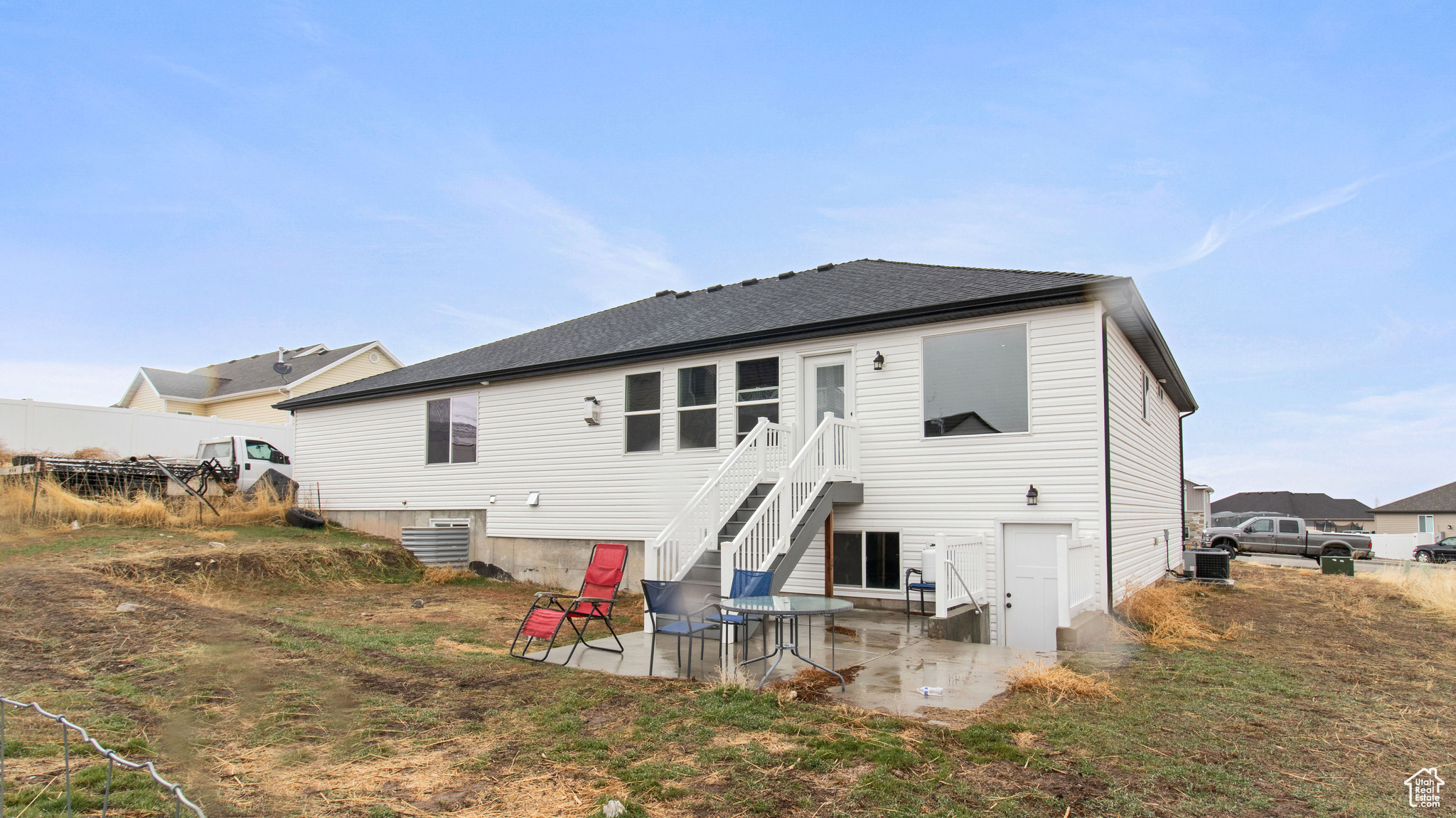 Rear view of property featuring a patio, roof with shingles, central AC, and fence