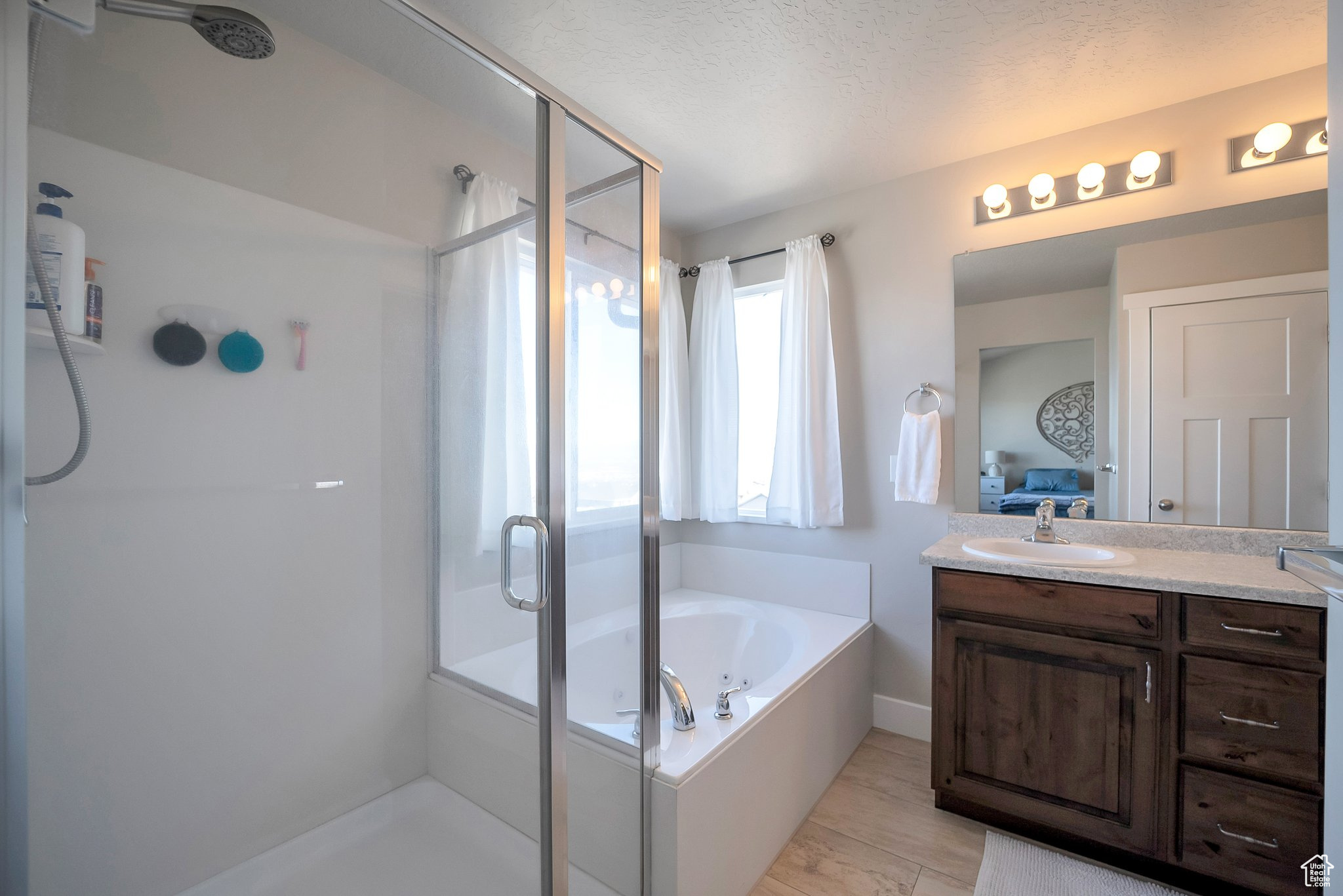 Full bathroom with vanity, a garden tub, a stall shower, and ensuite bathroom