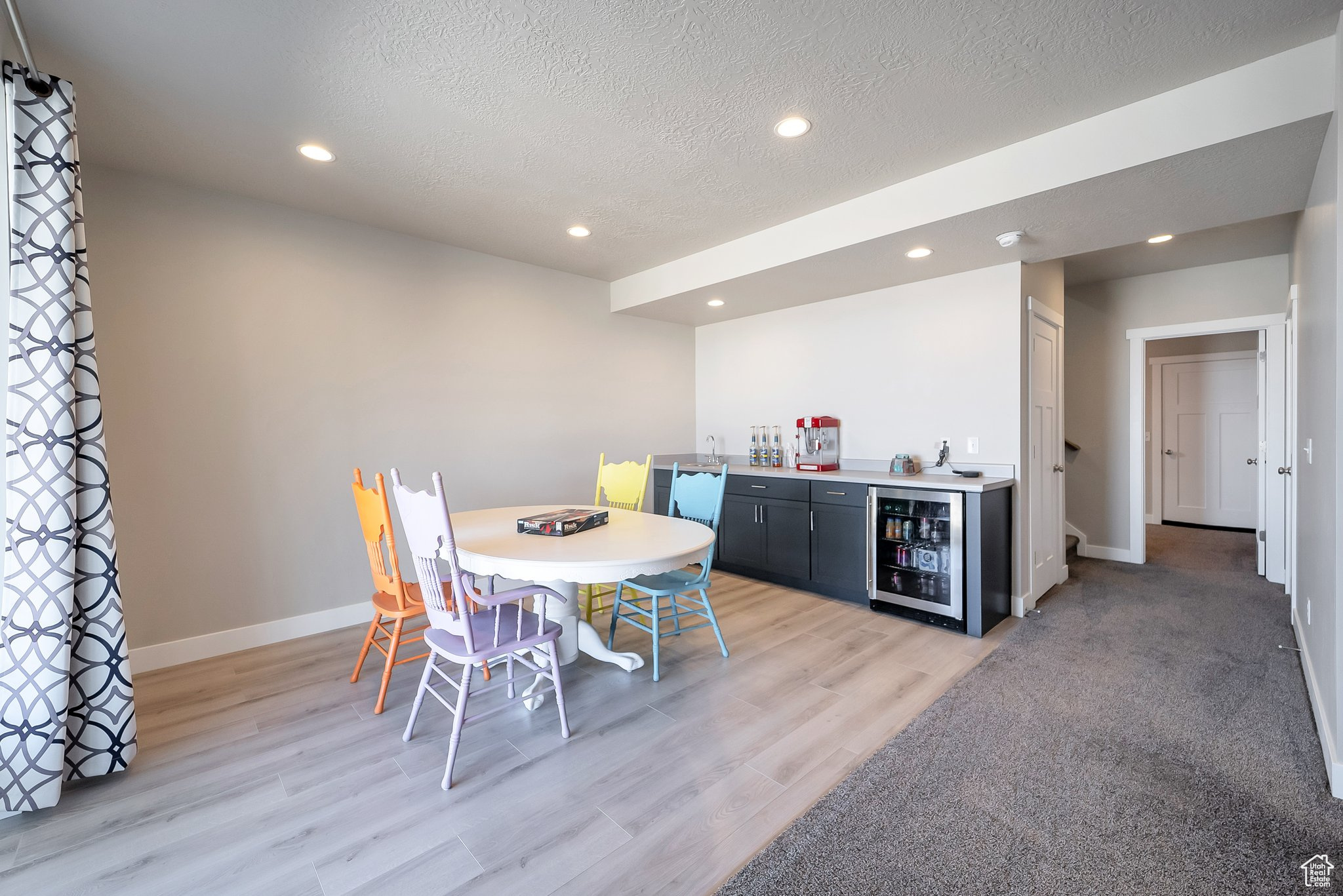 Dining room featuring baseboards, beverage cooler, a dry bar, recessed lighting, and a textured ceiling