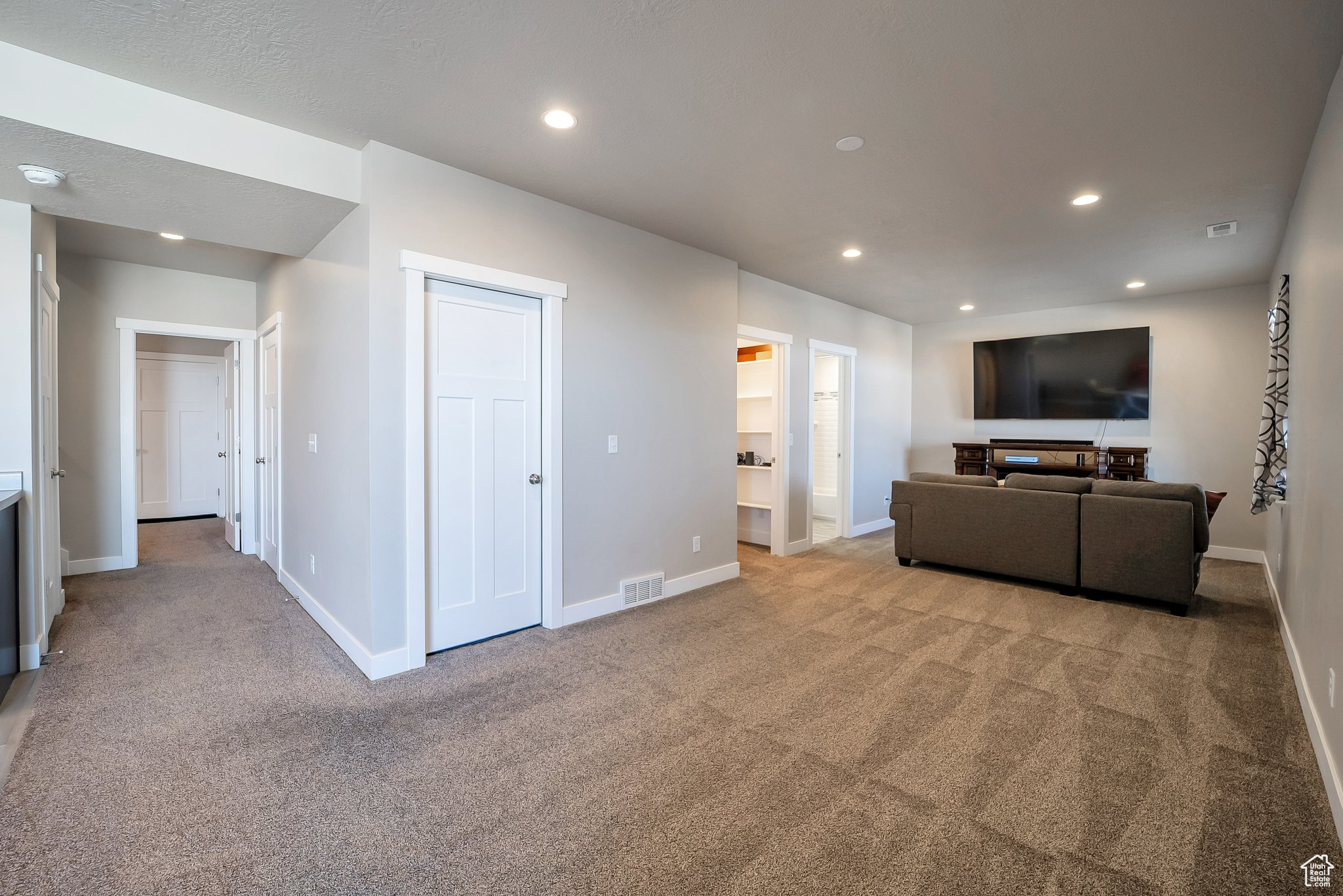 Living area featuring visible vents, recessed lighting, carpet flooring, and baseboards