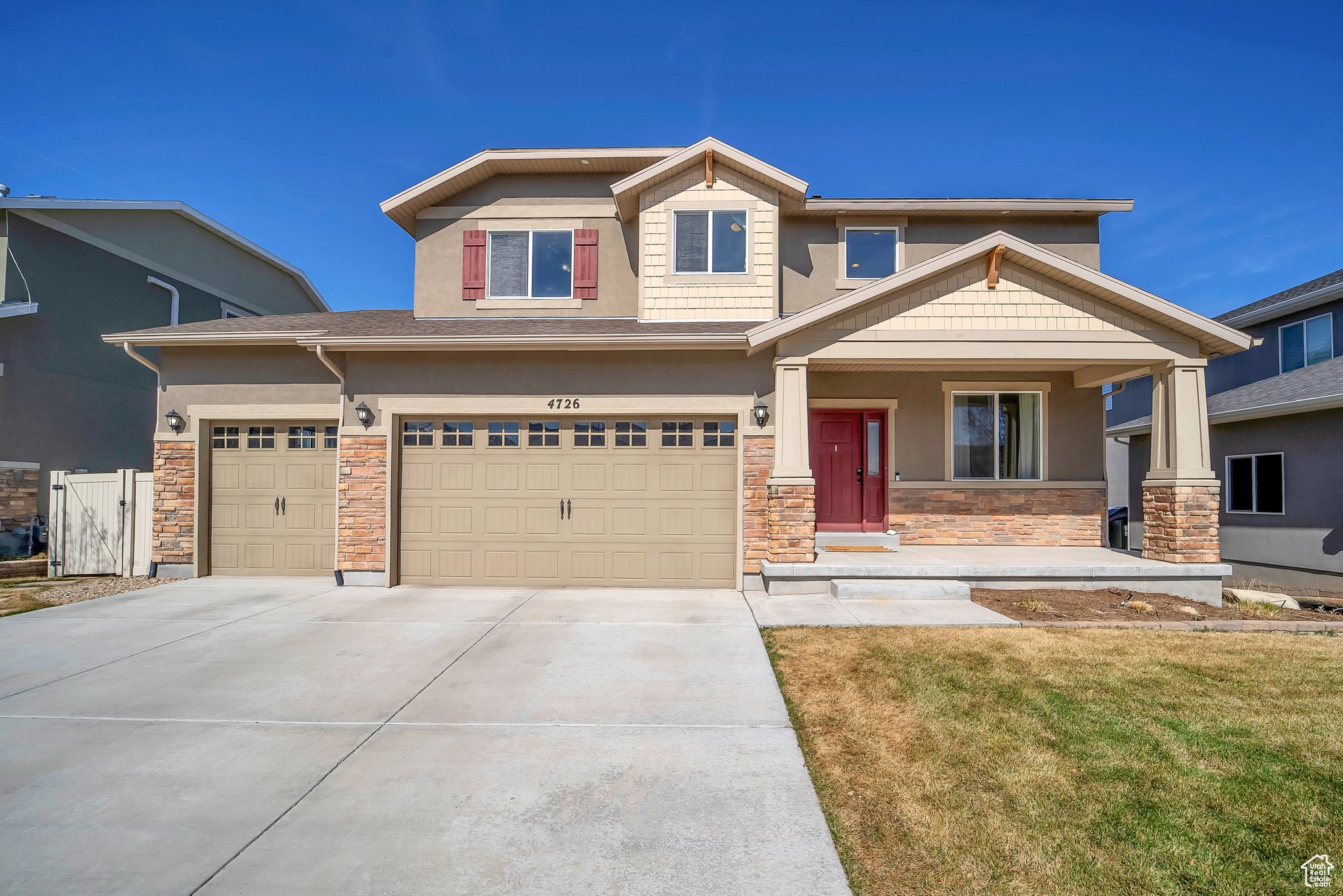 Craftsman house with fence, concrete driveway, a front yard, stucco siding, and stone siding