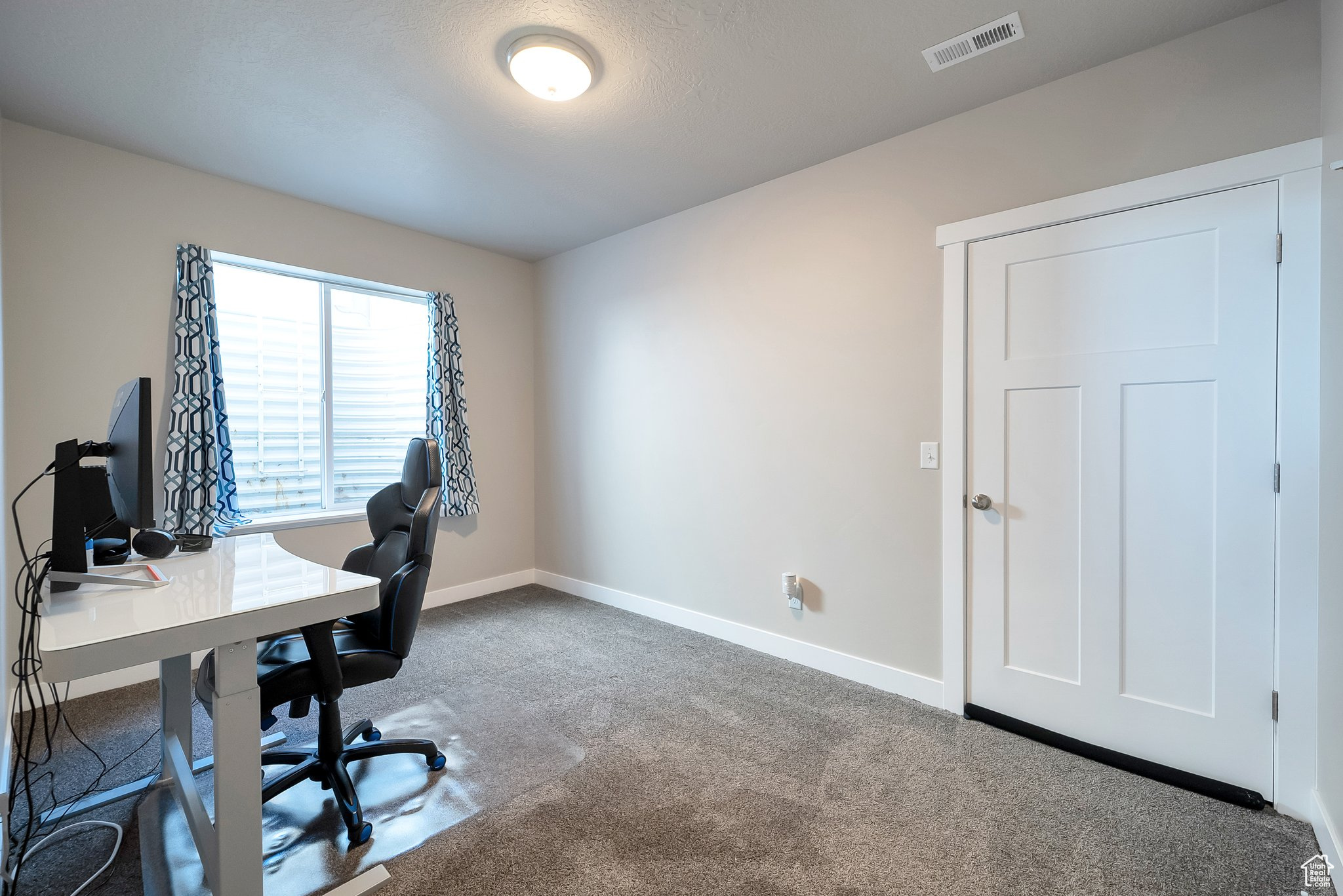 Carpeted office space with baseboards and visible vents