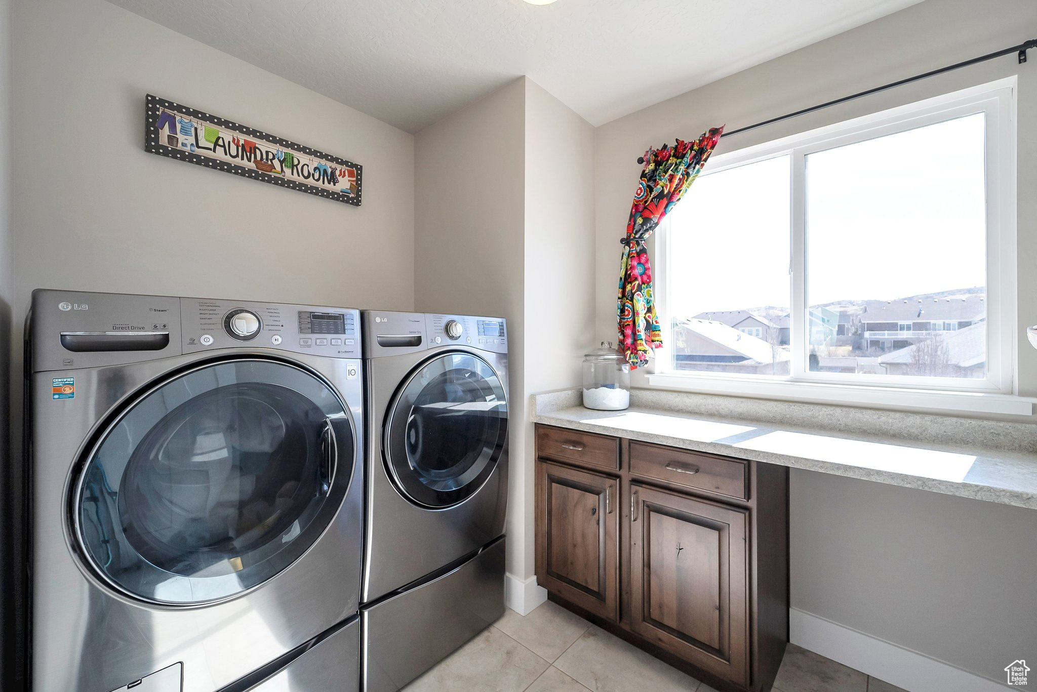 Washroom featuring laundry area, light tile patterned floors, and independent washer and dryer