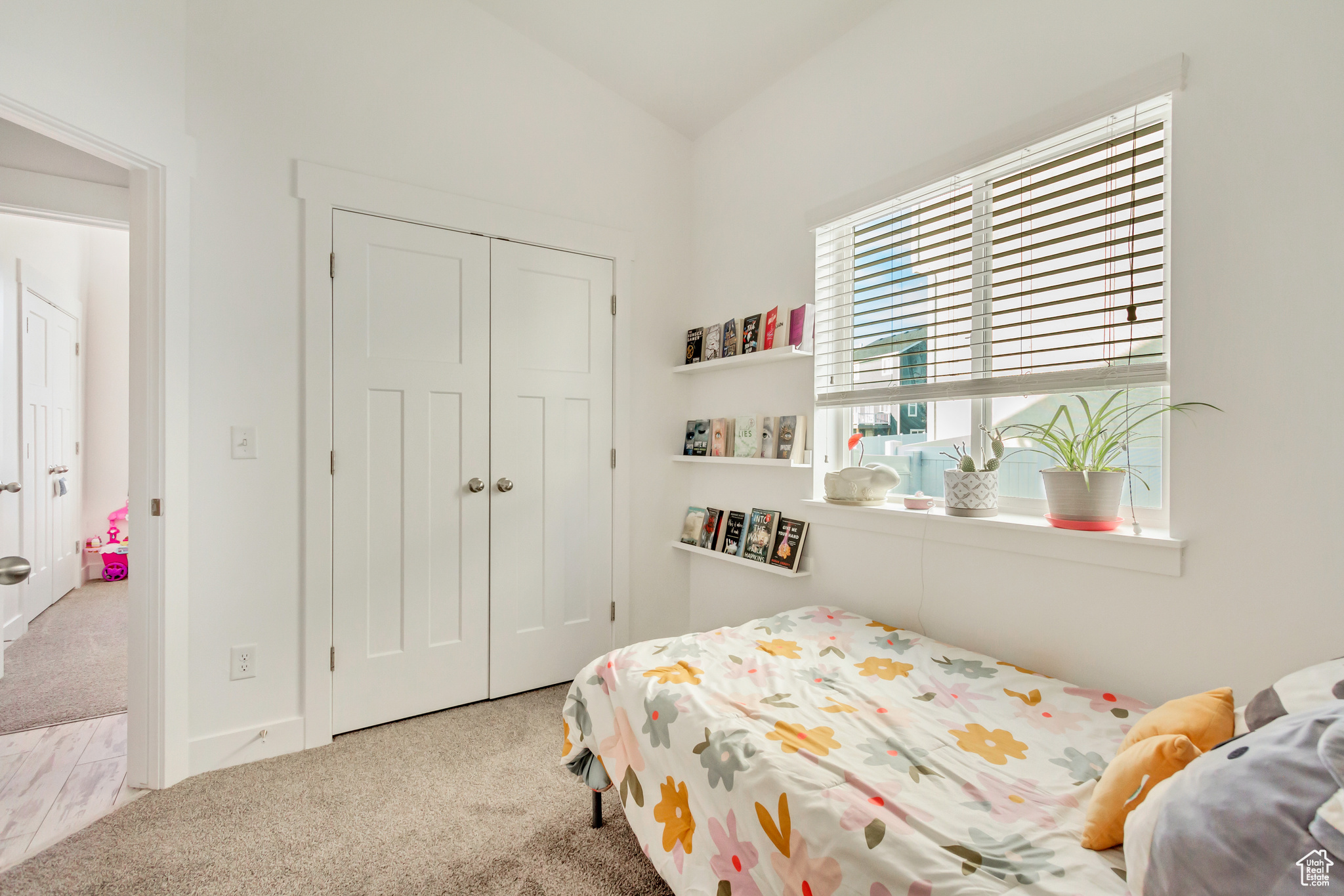 Bedroom with a closet, carpet flooring, and vaulted ceiling