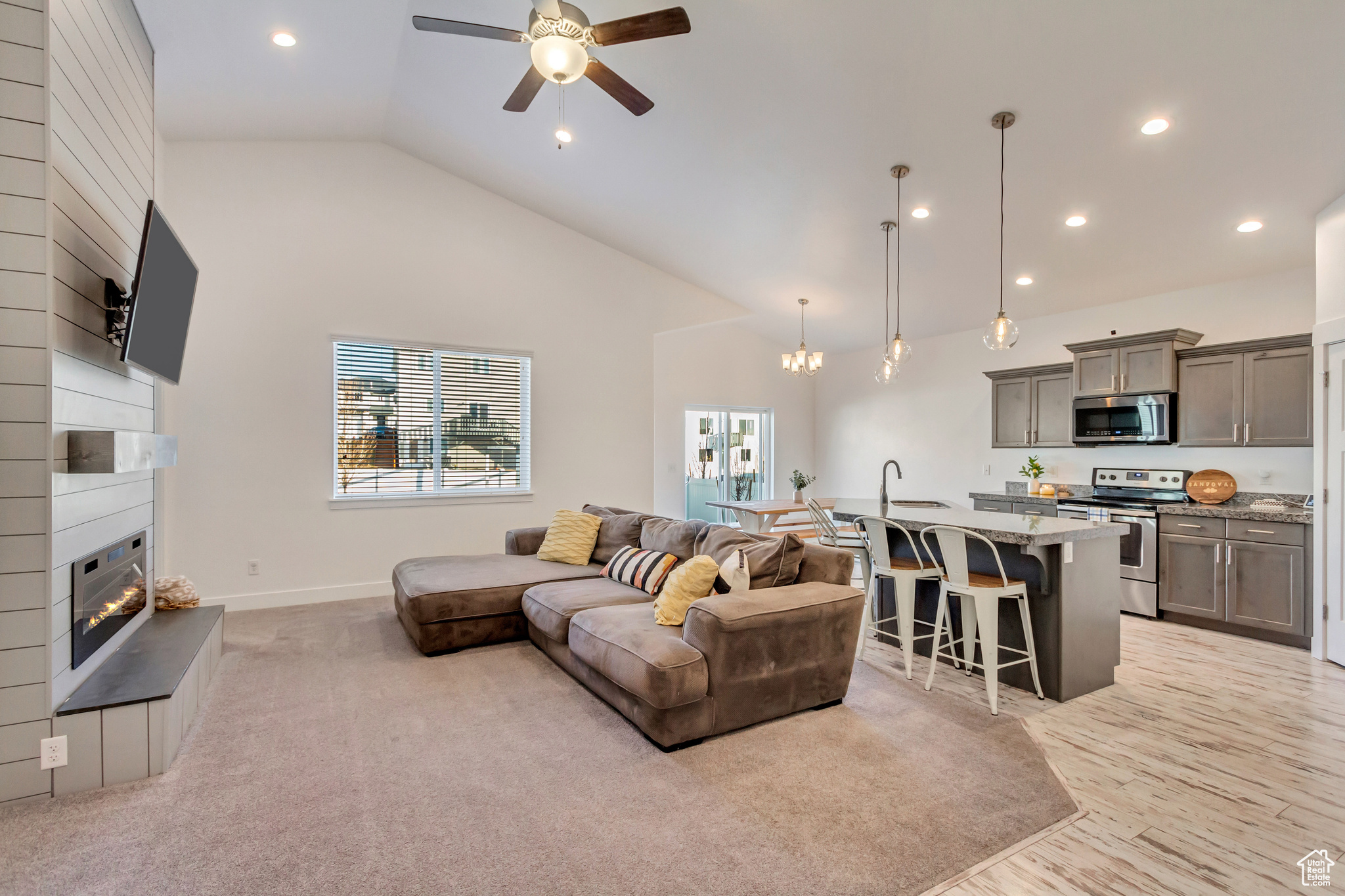 Living room featuring a ceiling fan, baseboards, high vaulted ceiling, recessed lighting, and a fireplace
