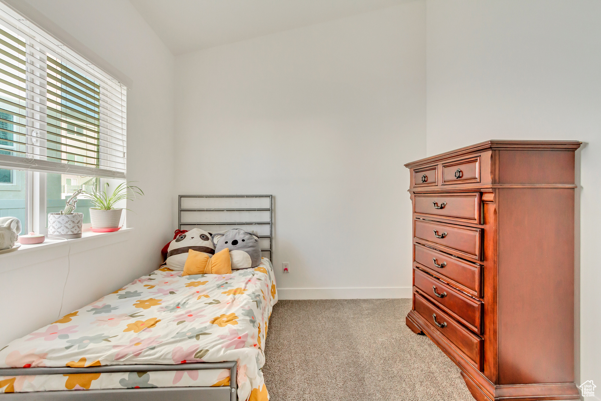 Bedroom with light colored carpet and baseboards