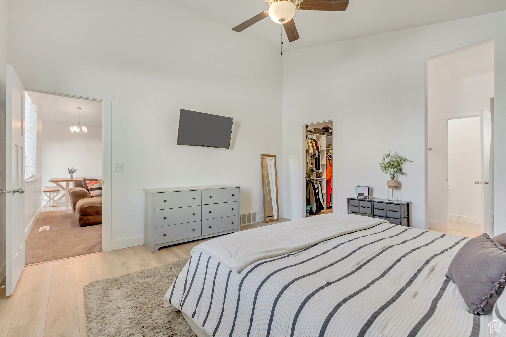 Bedroom featuring wood finished floors, visible vents, high vaulted ceiling, a closet, and a walk in closet