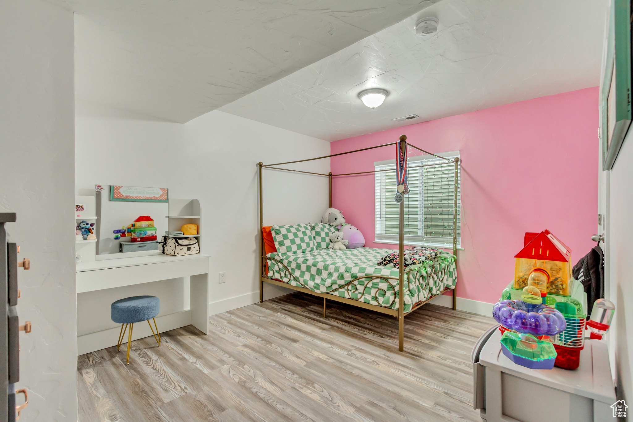 Bedroom with visible vents, baseboards, and wood finished floors