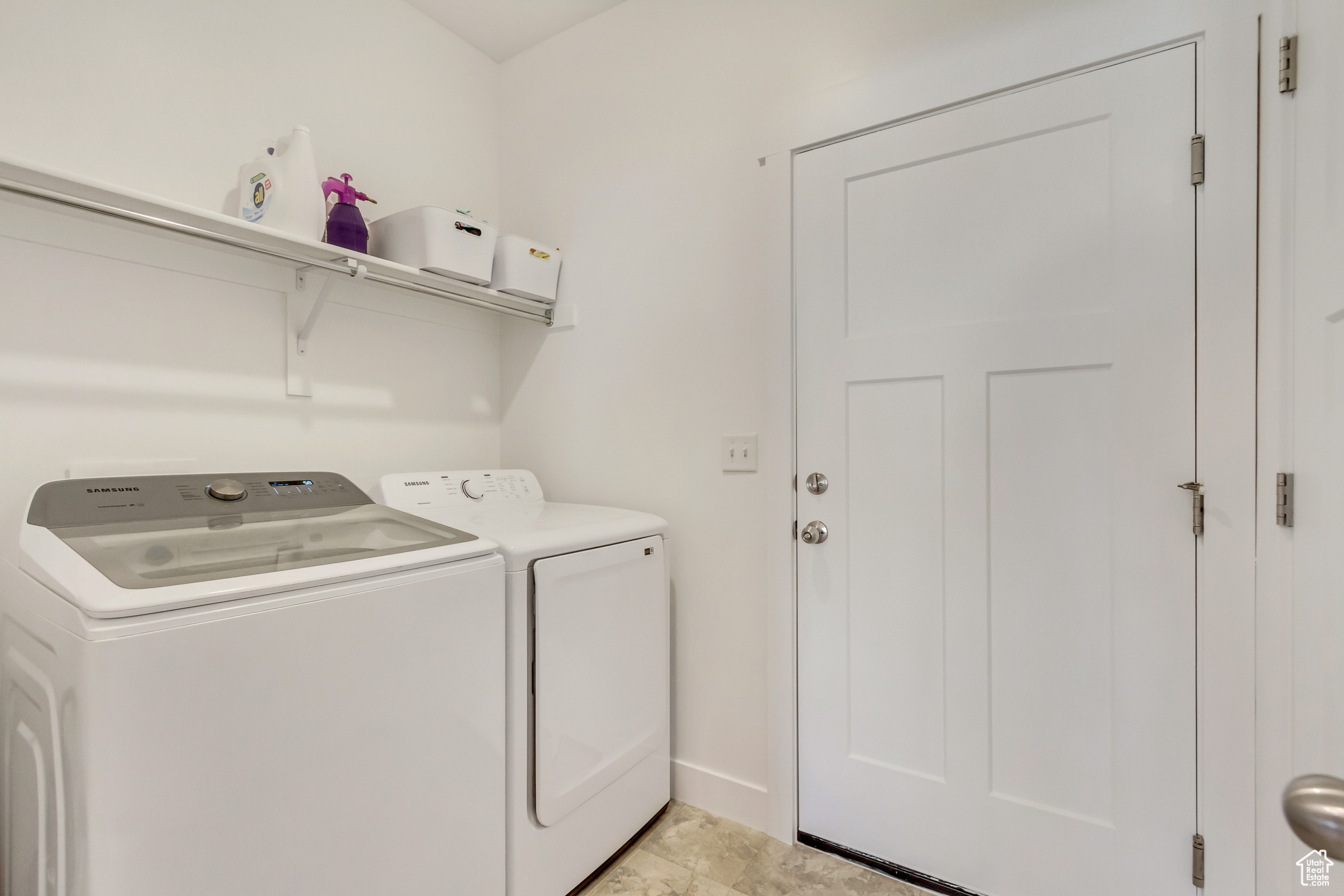Washroom with washer and dryer, laundry area, and baseboards