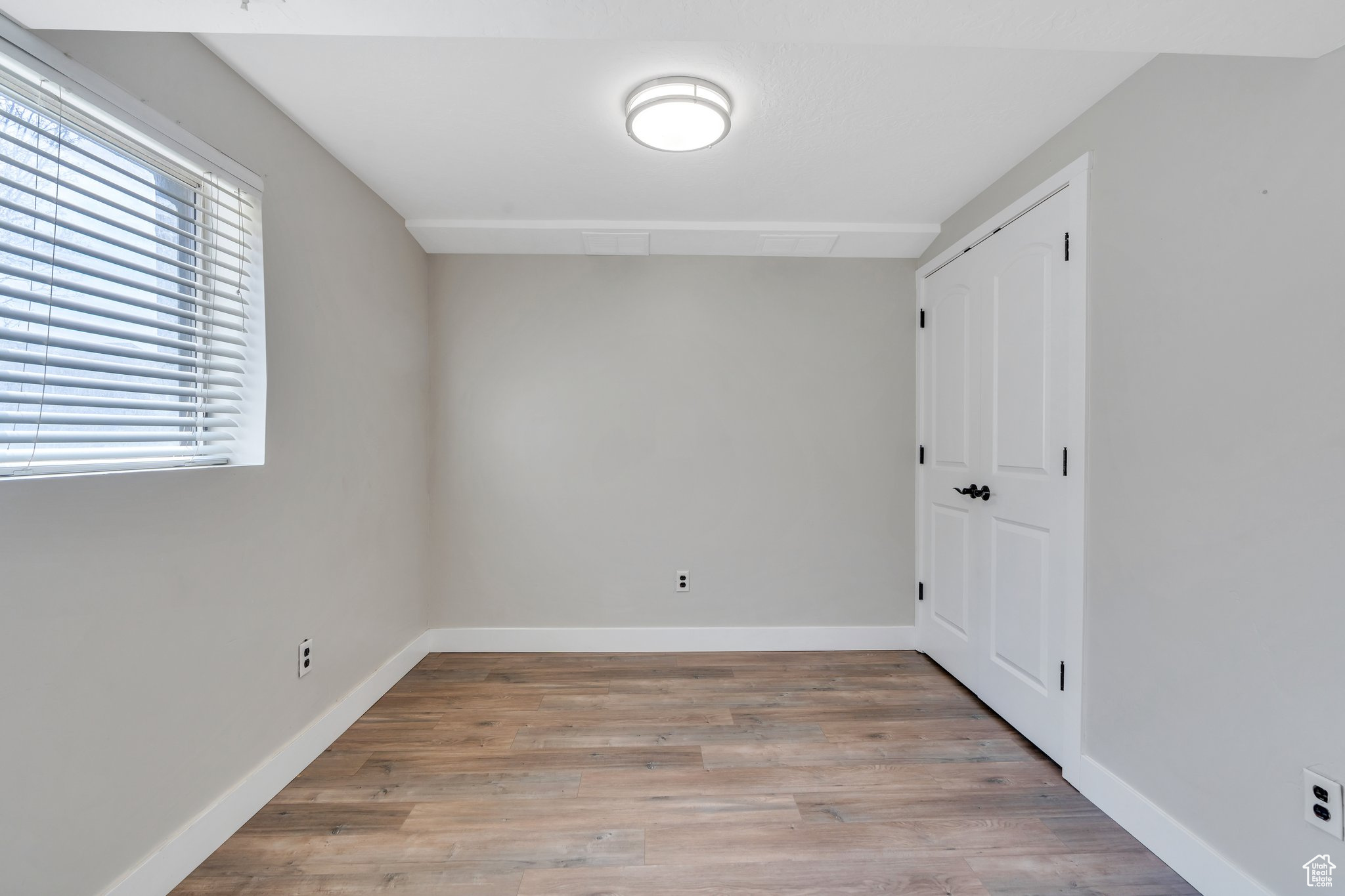 Interior space with a closet, baseboards, and light wood-style floors