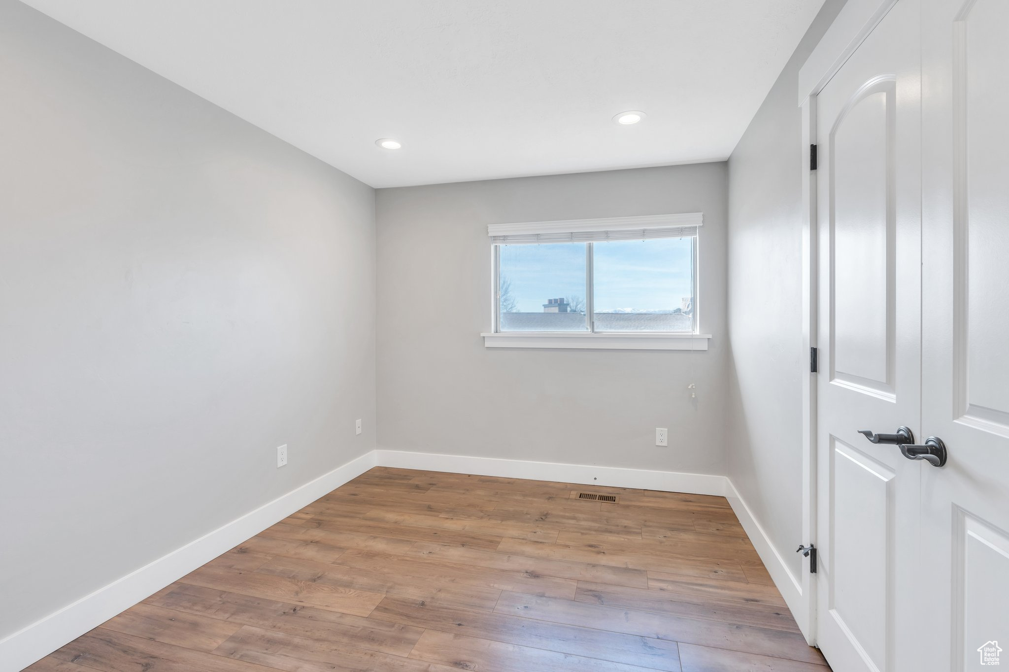 Empty room featuring recessed lighting, baseboards, and wood finished floors