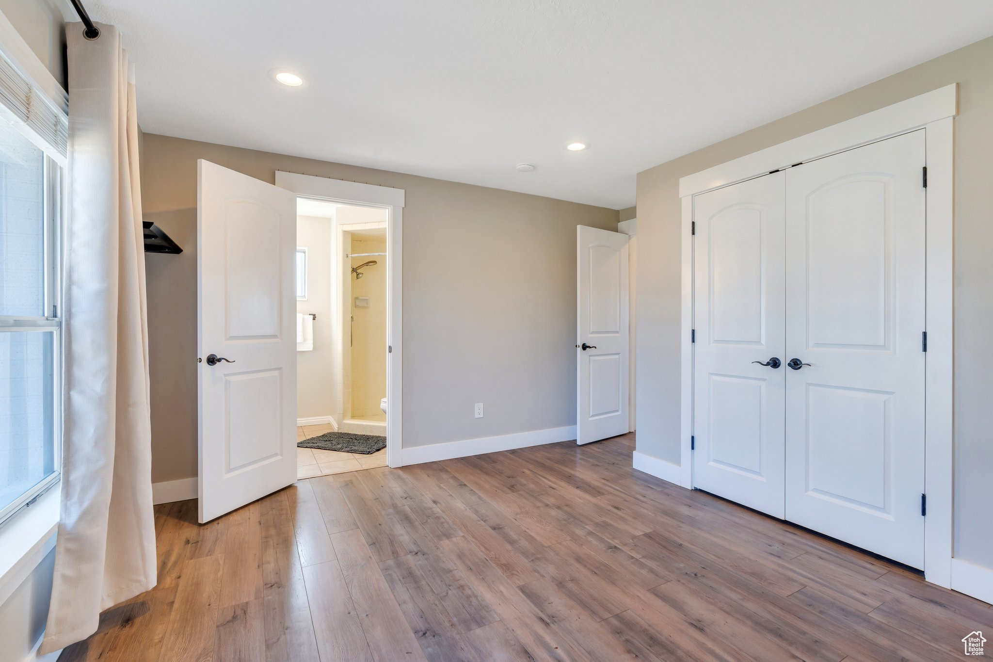 Unfurnished bedroom featuring light wood finished floors, recessed lighting, a closet, and baseboards