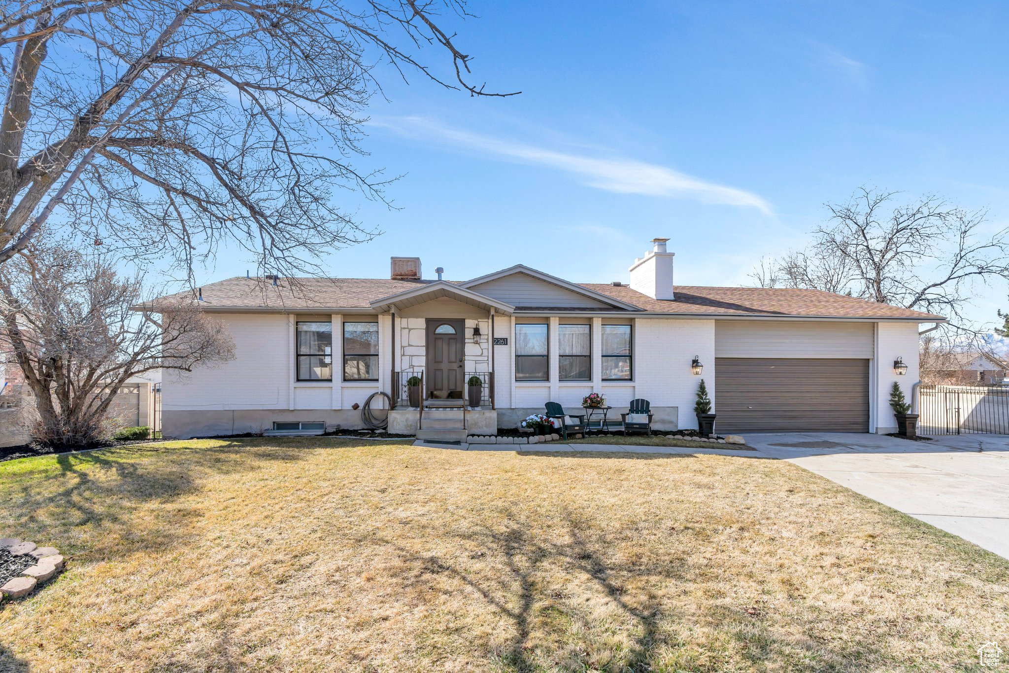 Single story home with a front lawn, fence, concrete driveway, a chimney, and a garage