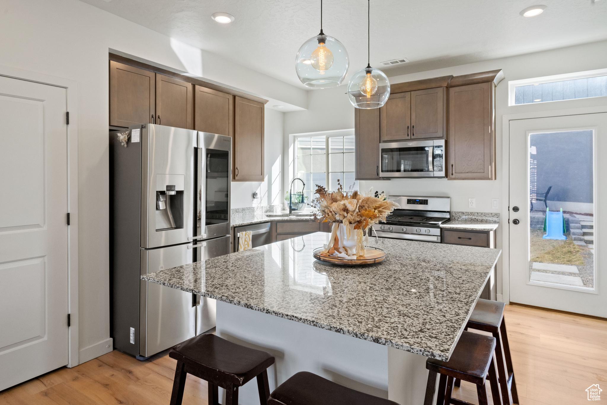 Kitchen featuring a sink, stainless steel appliances, a kitchen bar, and visible vents