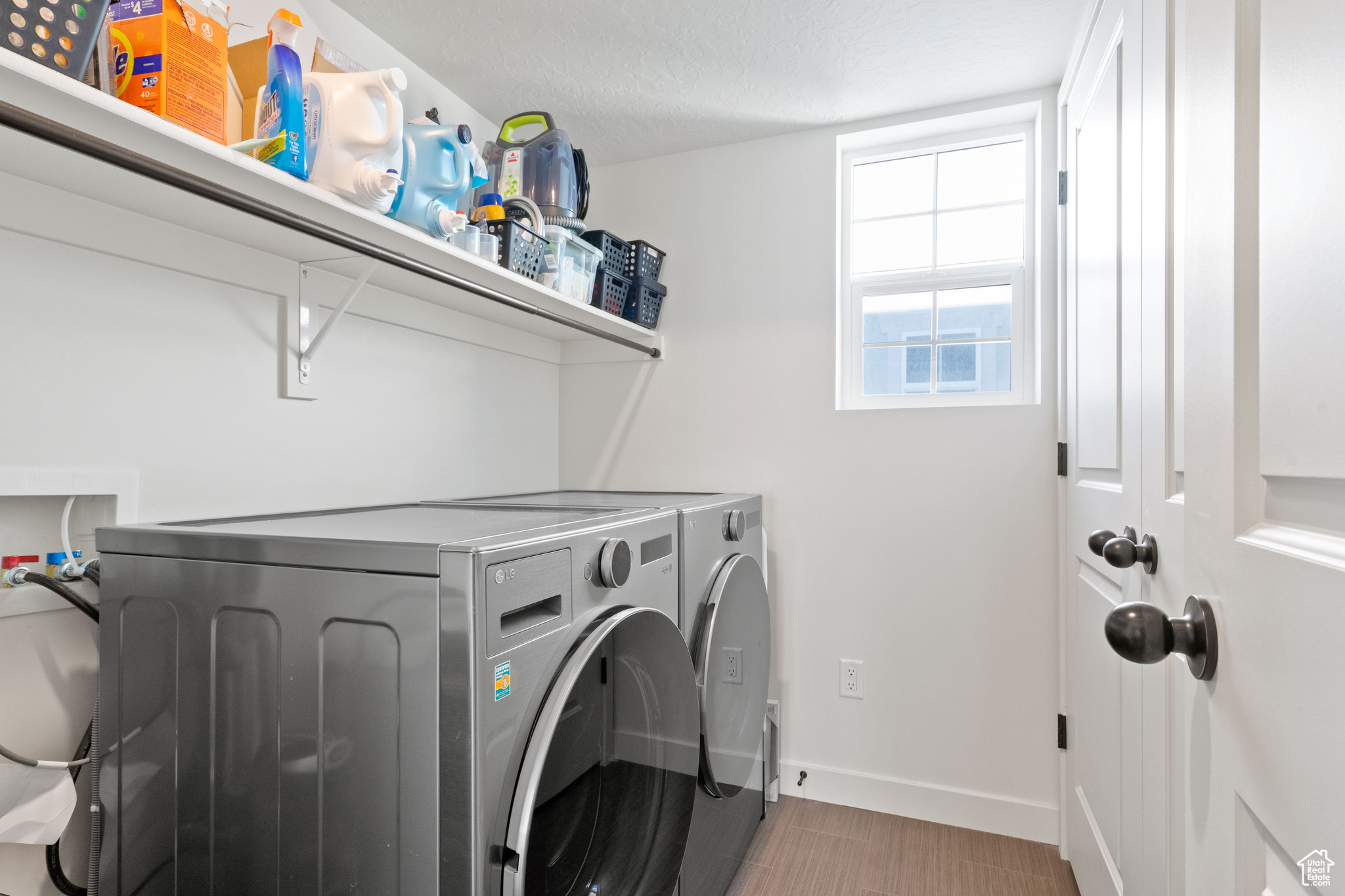 Washroom featuring laundry area, baseboards, and washer and clothes dryer