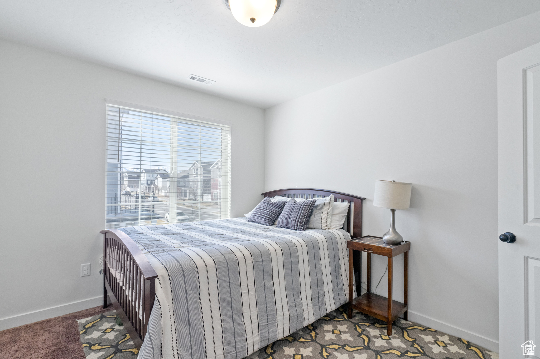 Carpeted bedroom with visible vents and baseboards