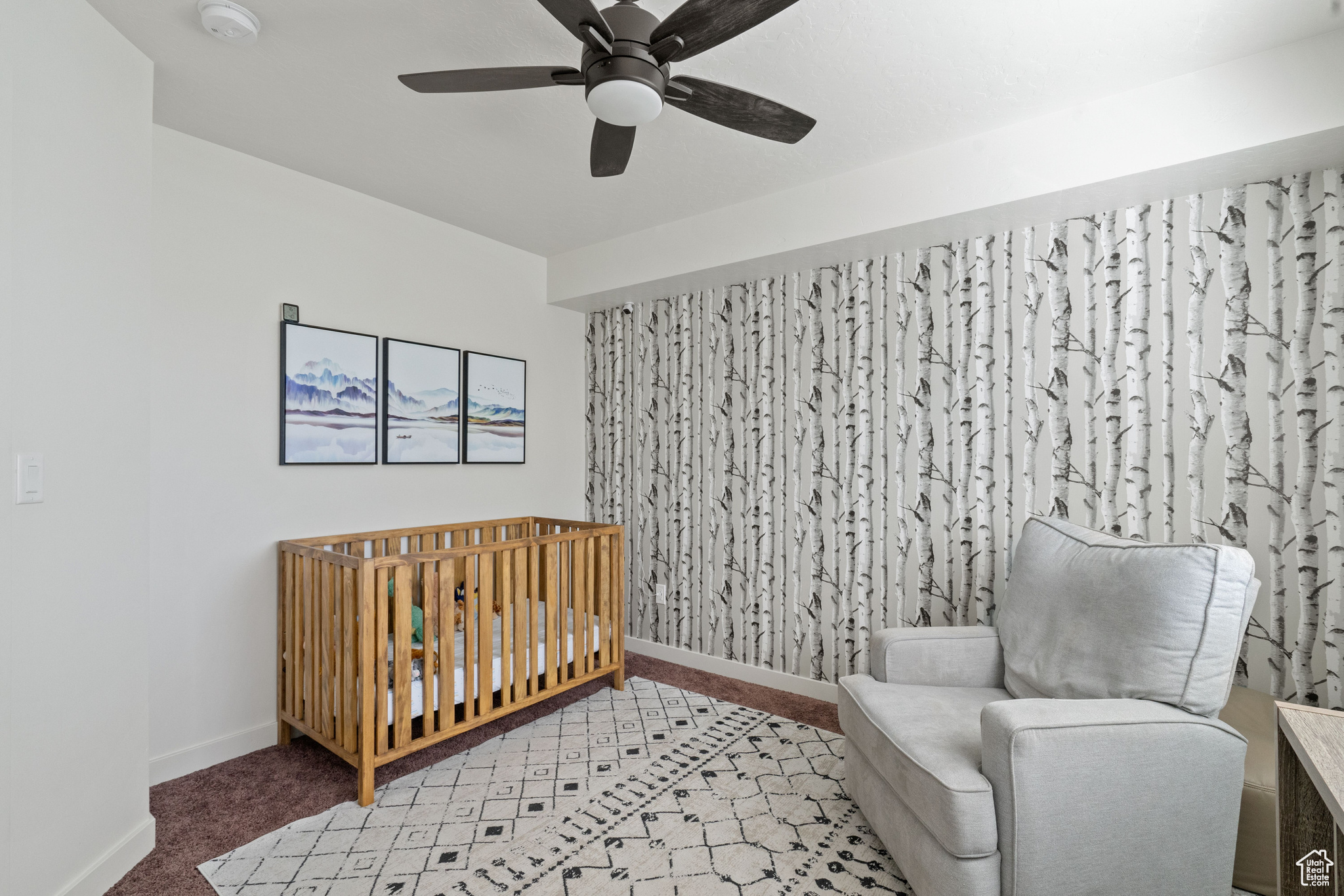 Bedroom featuring baseboards, light carpet, a crib, and a ceiling fan