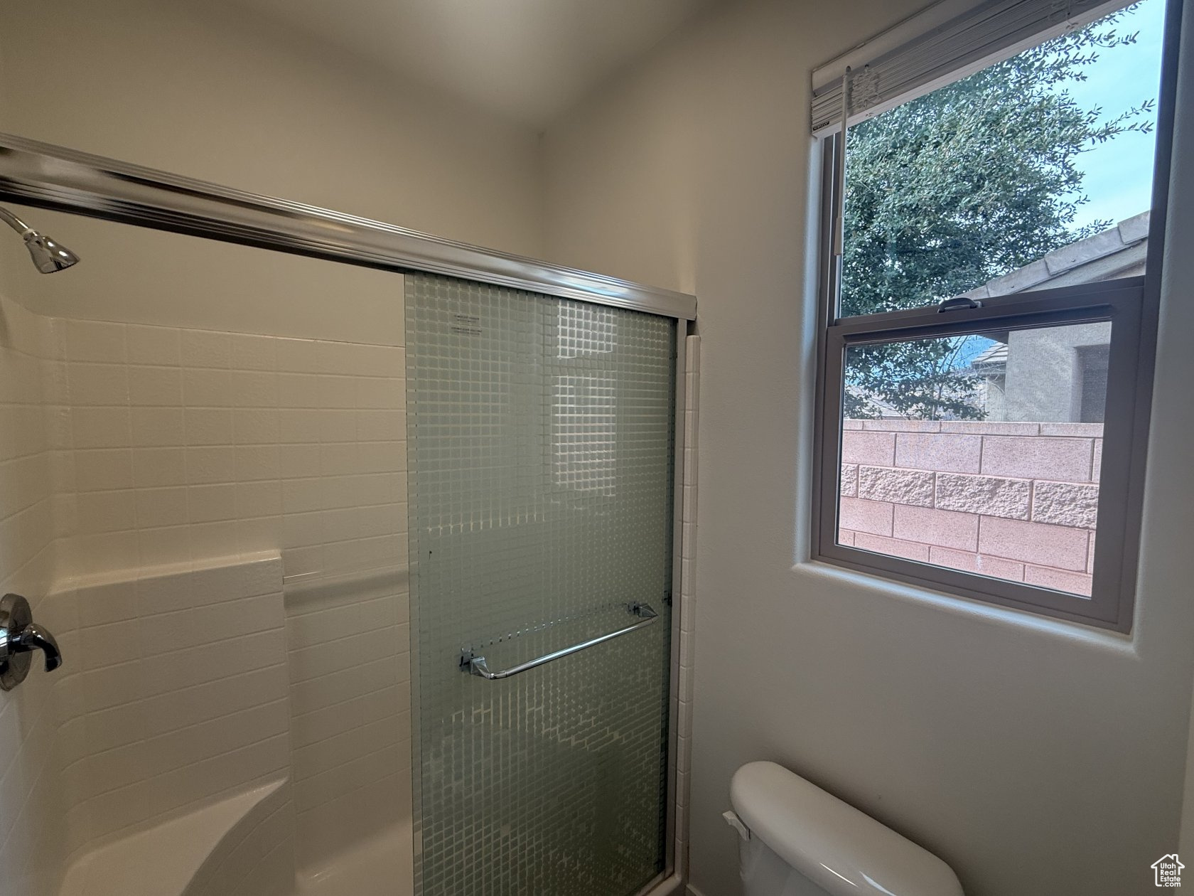 Full bathroom with toilet and a shower with door