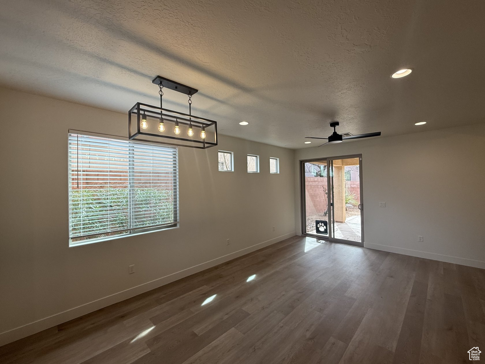 Spare room featuring recessed lighting, a textured ceiling, baseboards, and wood finished floors