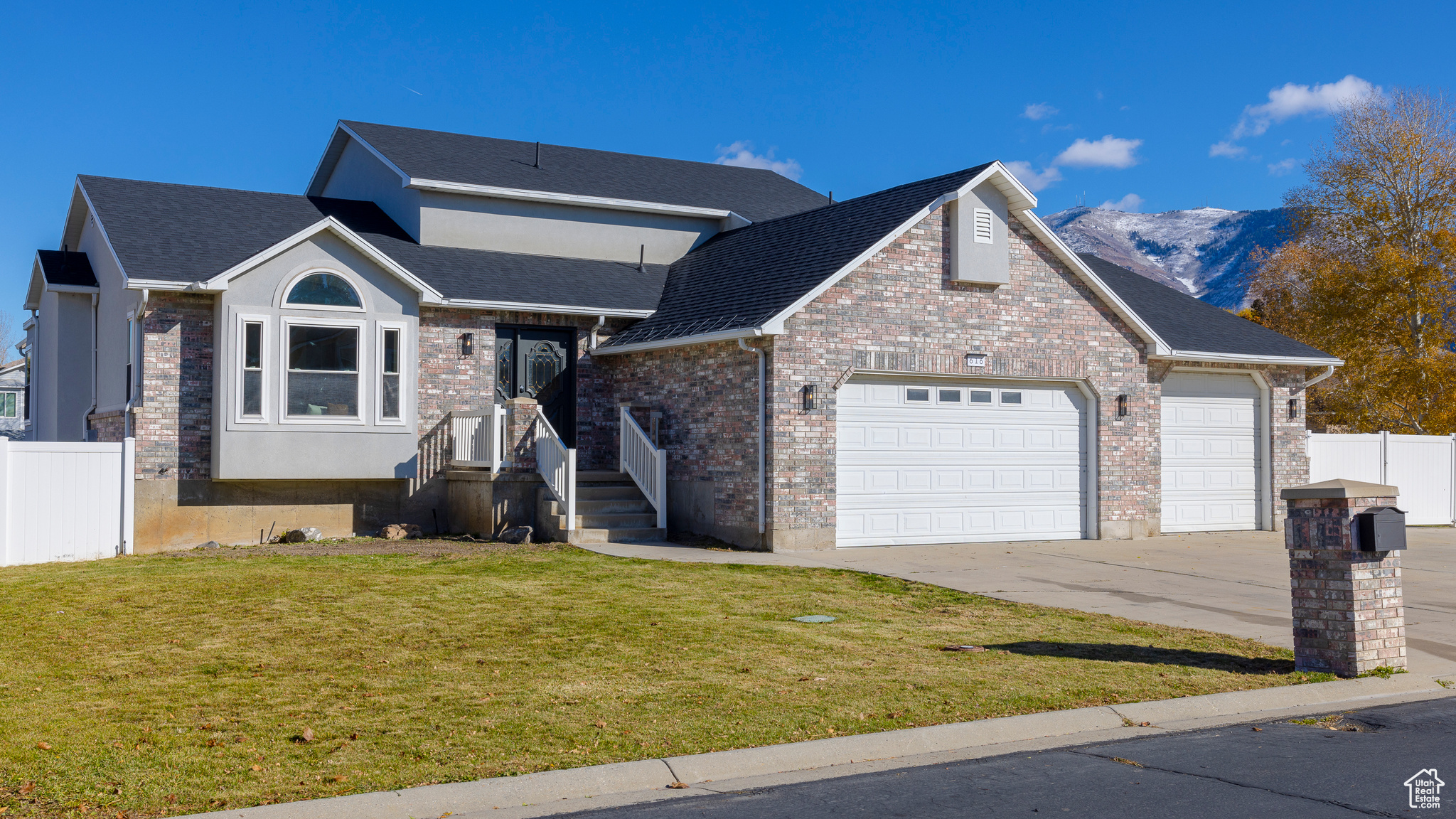 View of front of home featuring a garage, fence, driveway, and a front lawn