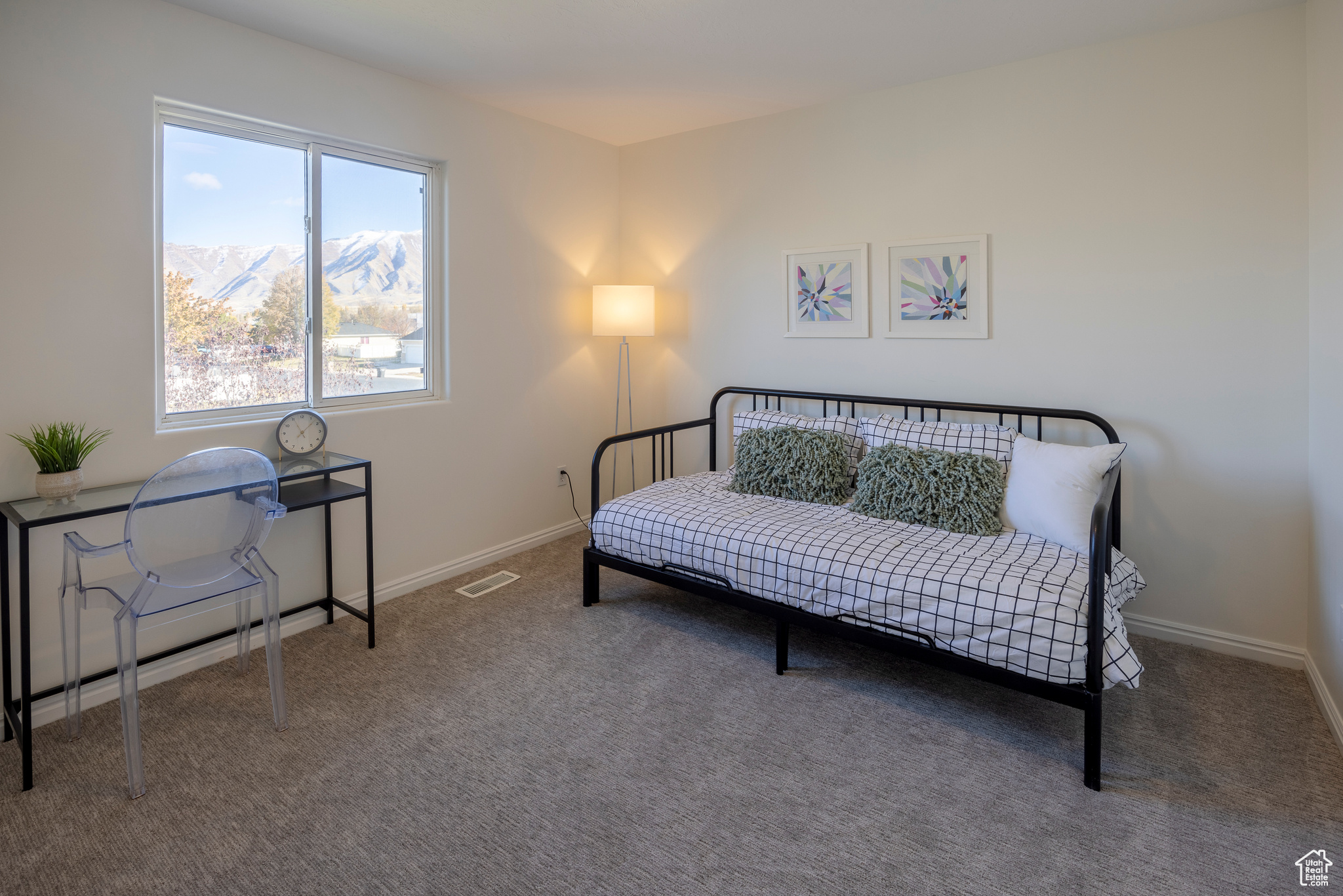 Living area with a mountain view, carpet, visible vents, and baseboards