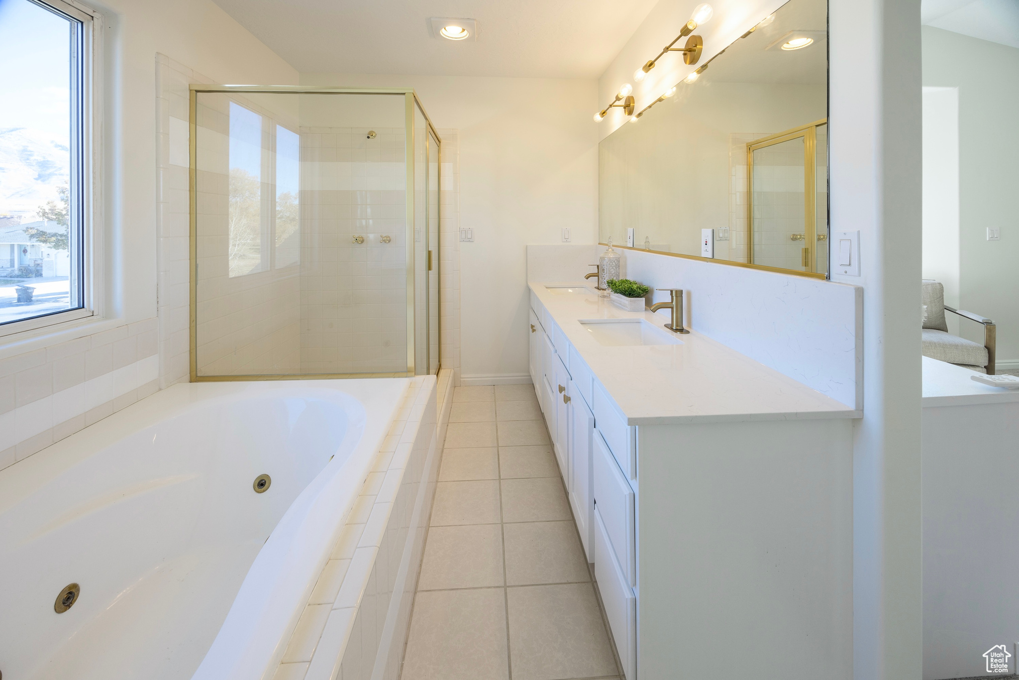 Bathroom with a stall shower, a sink, a tub with jets, and tile patterned floors